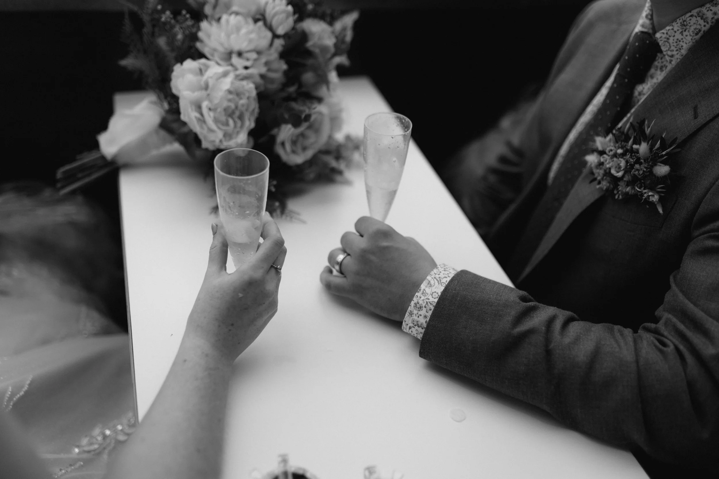  A detailed shot of the bride and groom sharing a drink on their wedding day in the Lake District. 