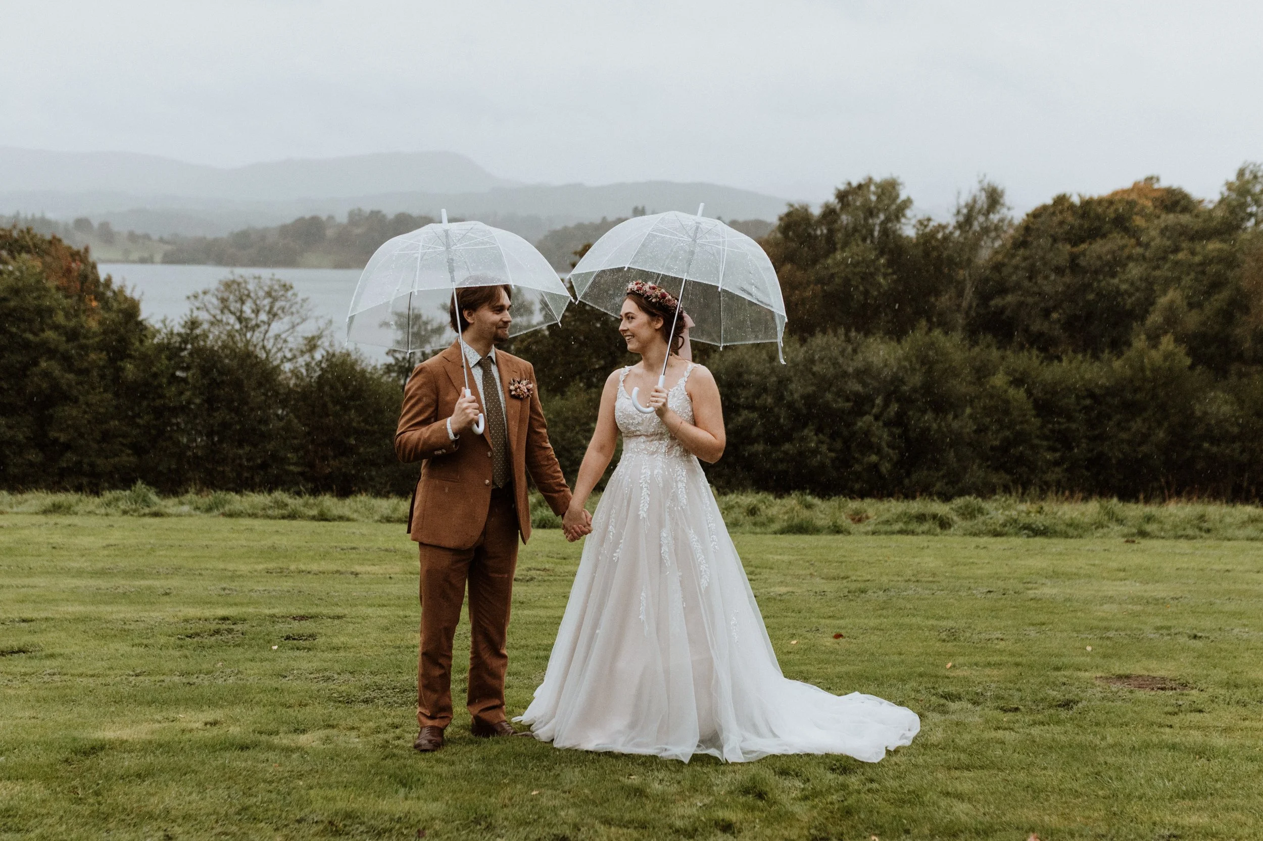  Bride and groom under an umbrella during a rainy Lake District wedding. 