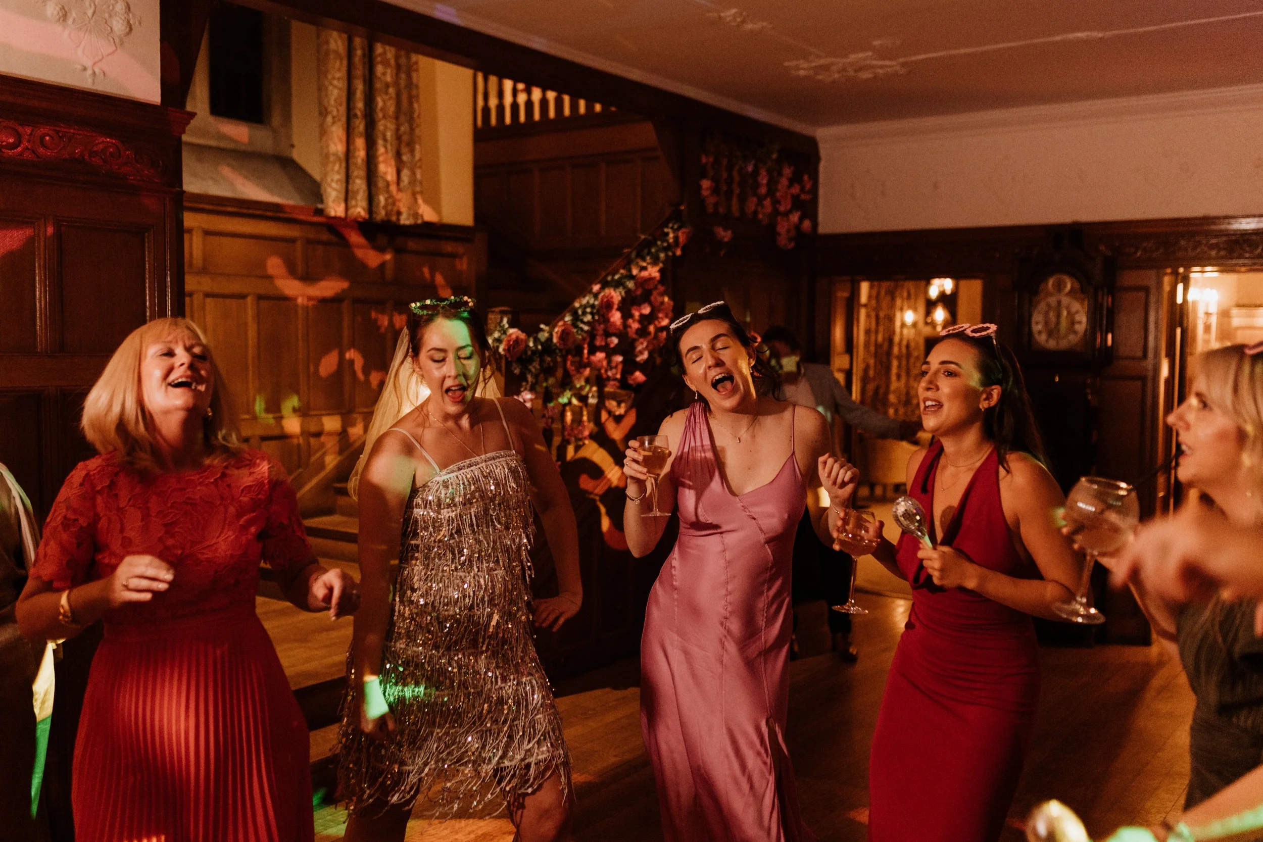 The bride and her friends dance on the dance floor at their Lake District wedding. 