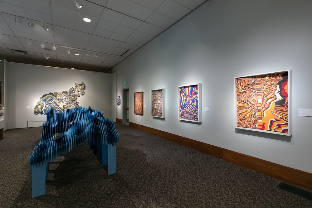 Edge on view of "Sneffles Skyline" in the foreground, "Watershed Moments" in the left background, and four altered topographic sculpture on the right wall
