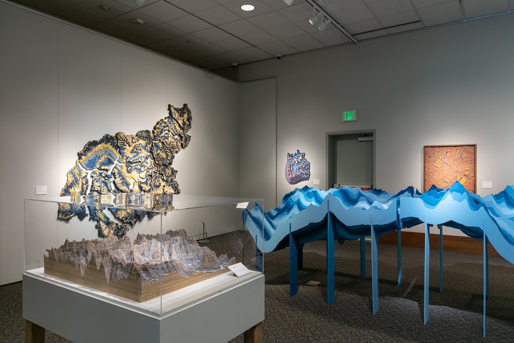 "elk Mountains" in the foreground, "Watershed Moments" on the left back wall, and "Sneffles Skylines" to the right