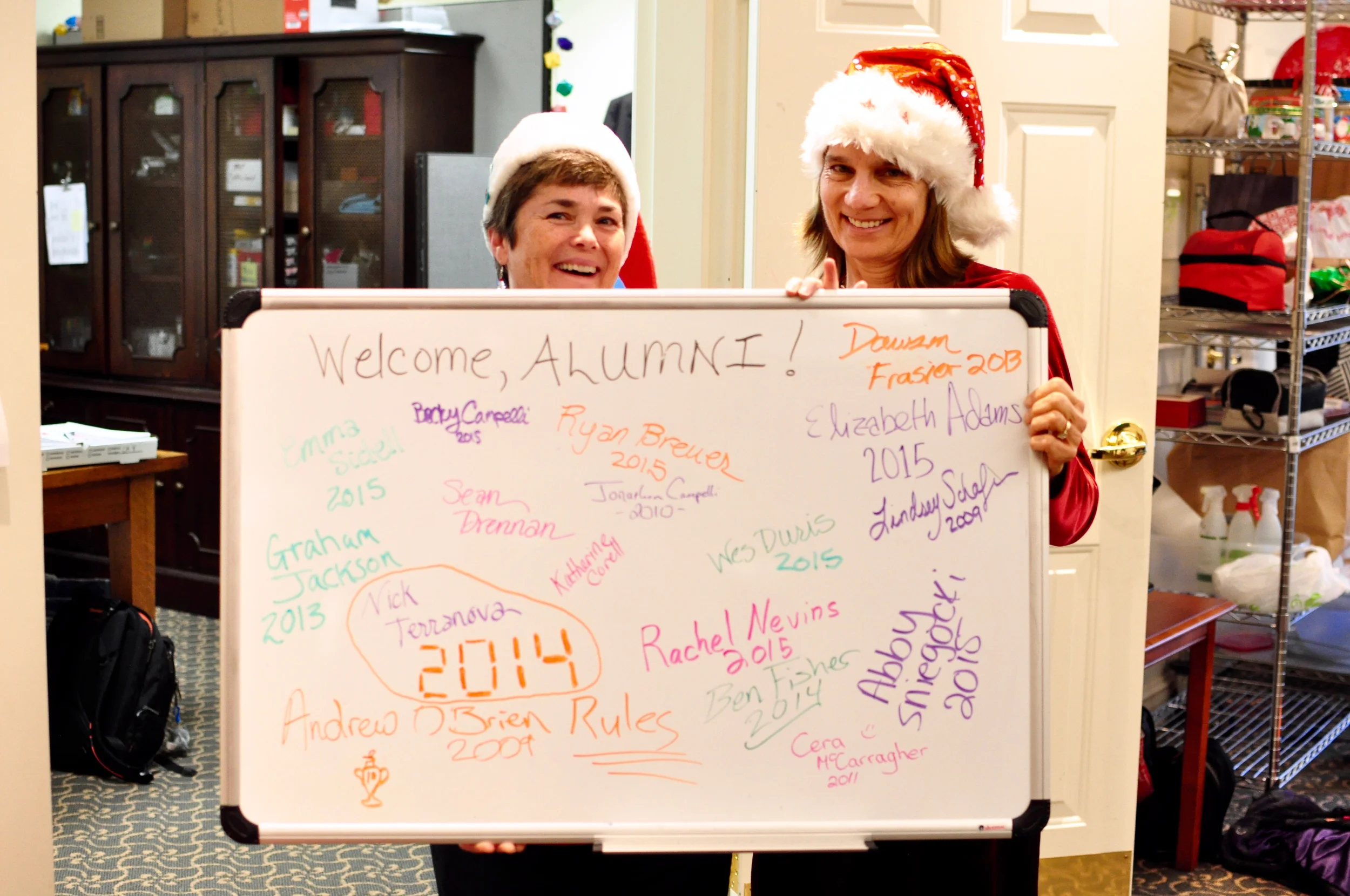 Mrs. Geraghty and Mrs. Ahearn with the board signed by the alumni today.