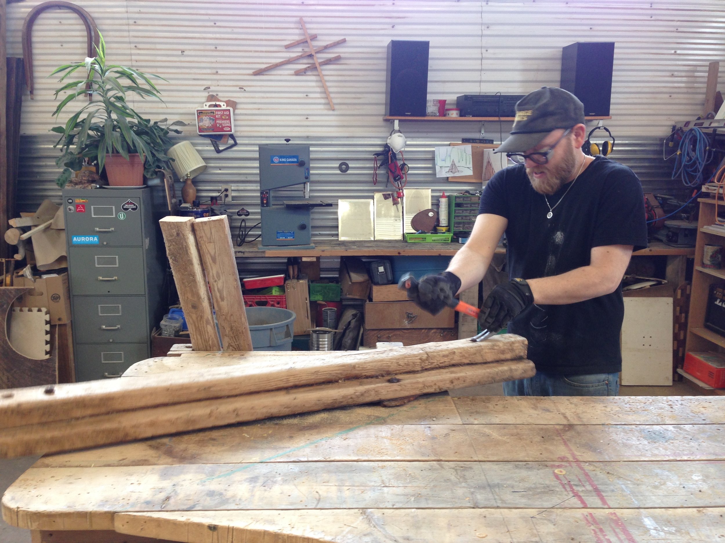 Lenny taking apart the bolted wood from the cattle barn.