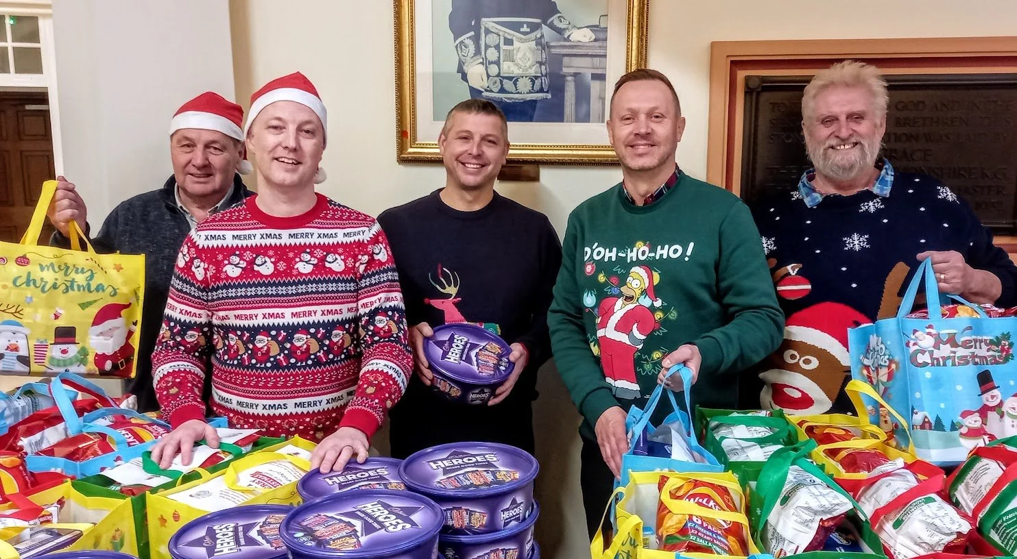 This is a photo of Martin Morgan, warehouse controller at MTMS, Lee Hampton, head of marketing and systems, Peter Stretton, operations manager, Matt Forst, managing director and Malcolm Prentice, group chairman. They are all wearing Christmas jumpers