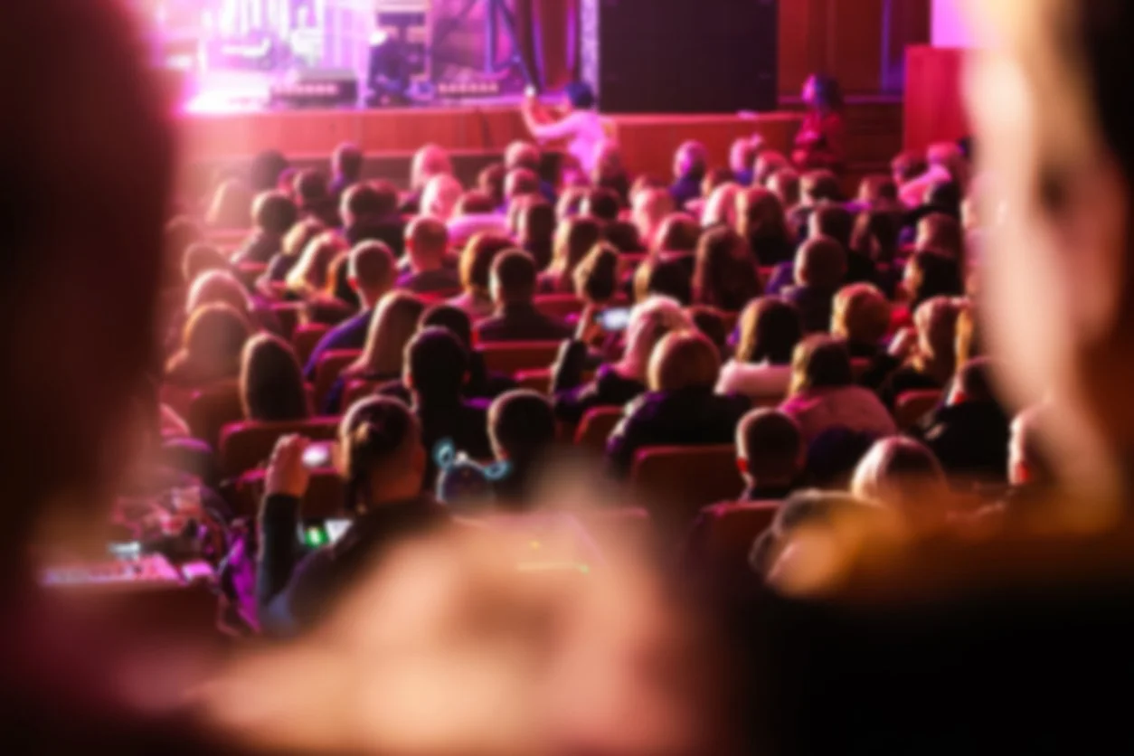 large audience seated in a majestic theater