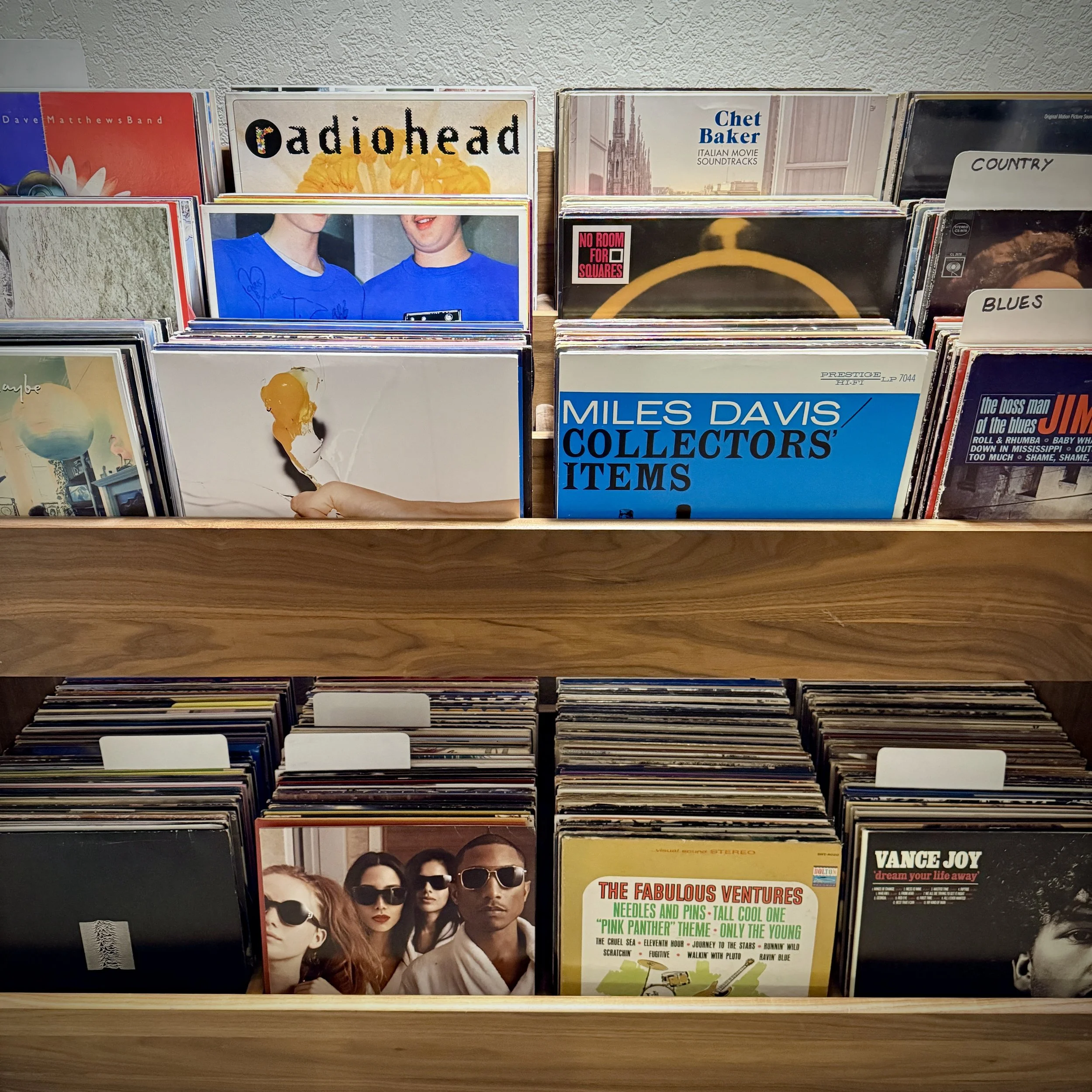 Collection of vinyl record albums on wooden shelves