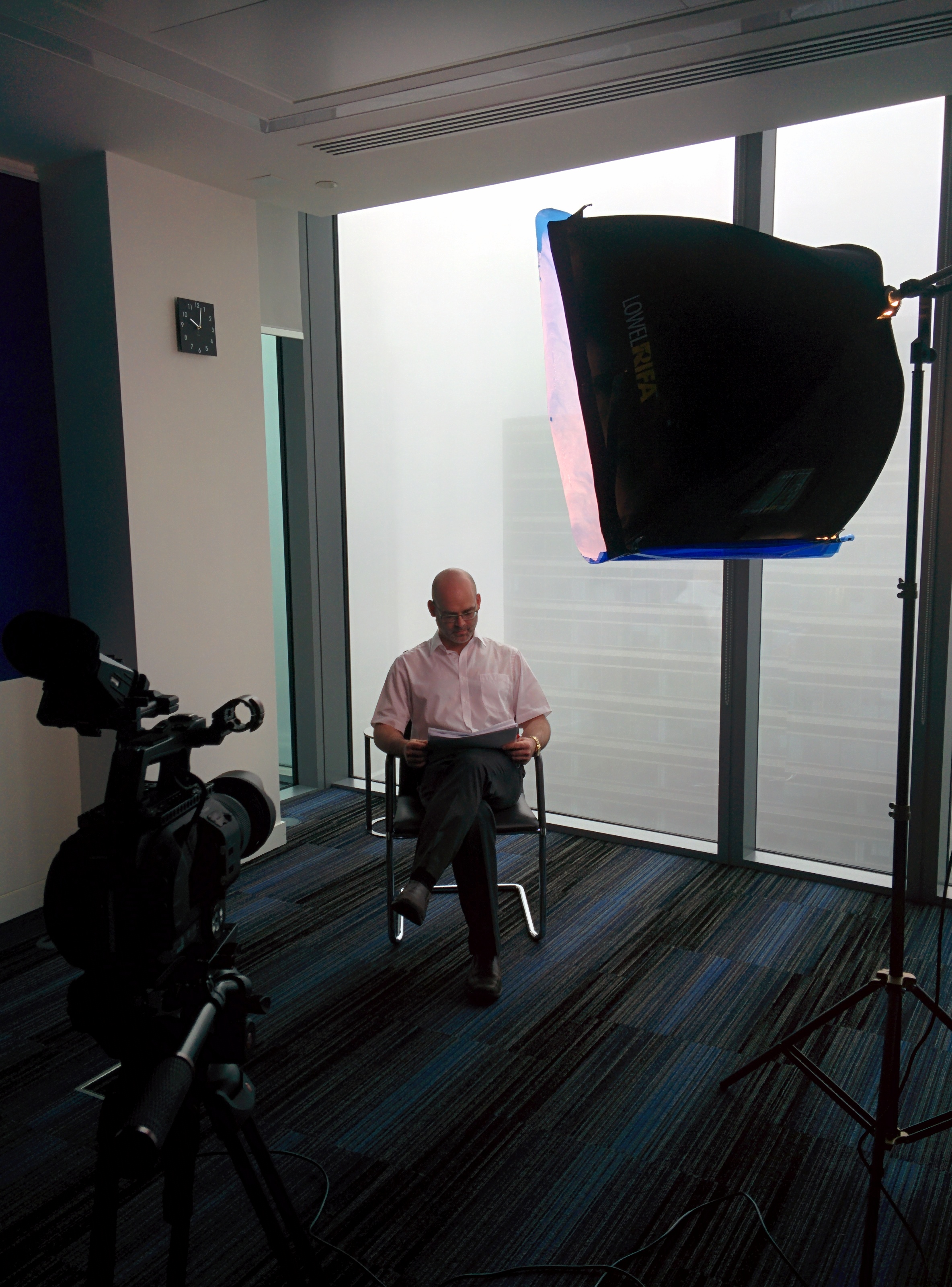 Nat prepared to interview someone at the top of a very tall tower on a very misty day in Canary Wharf.