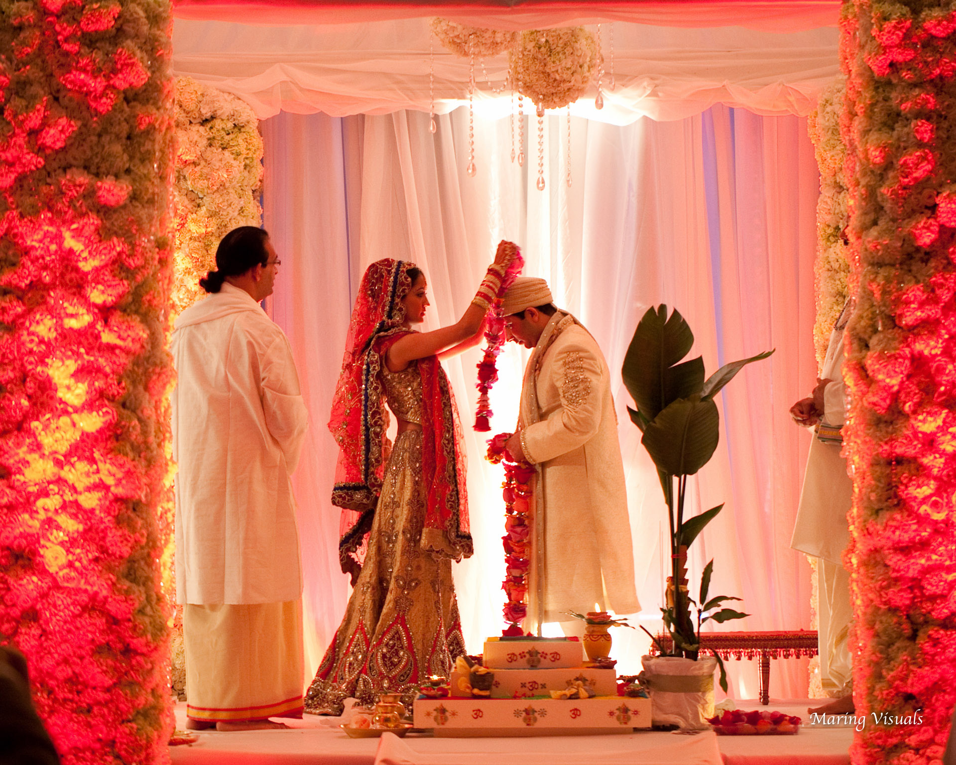 The bride and groom exchanage garlands during their traditional hindu ceremony