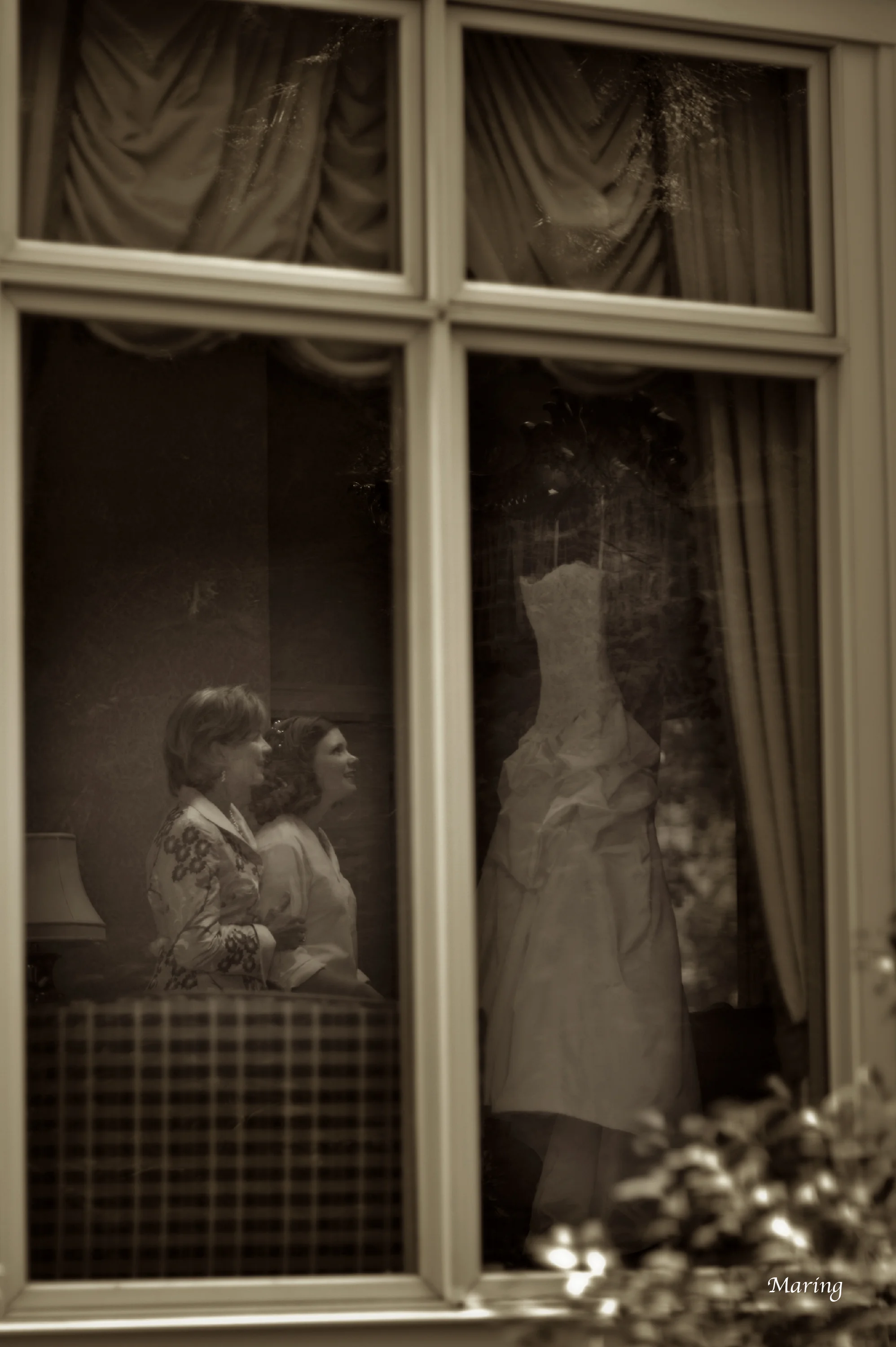 The bride and her mom peer at the wedding dress in a room designated for the bride to get ready. Having a peaceful place to slip on your wedding gown or tux on is something that we recommend each couple consider
