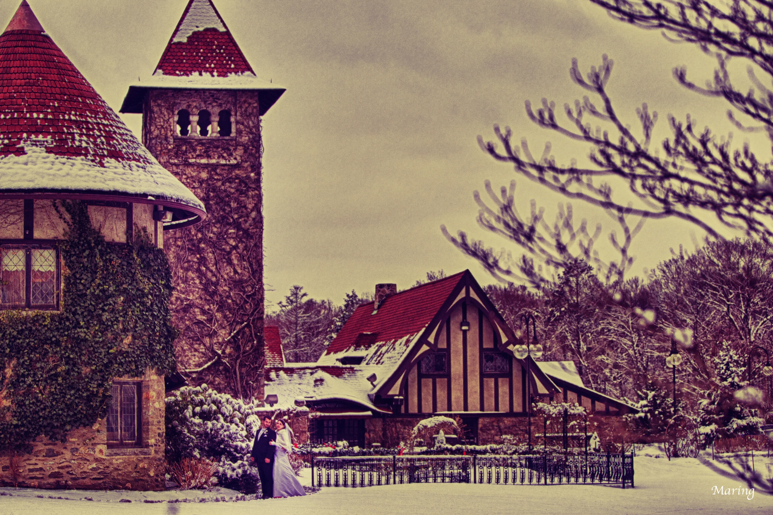 A bride and groom pose for a photograph at Saint Clements Castle as photographer Charles Maring wades out into the deep snow to capture the scene.
