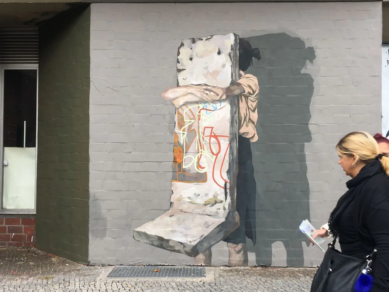 This work was painted on canvas covering the brick making it removable.