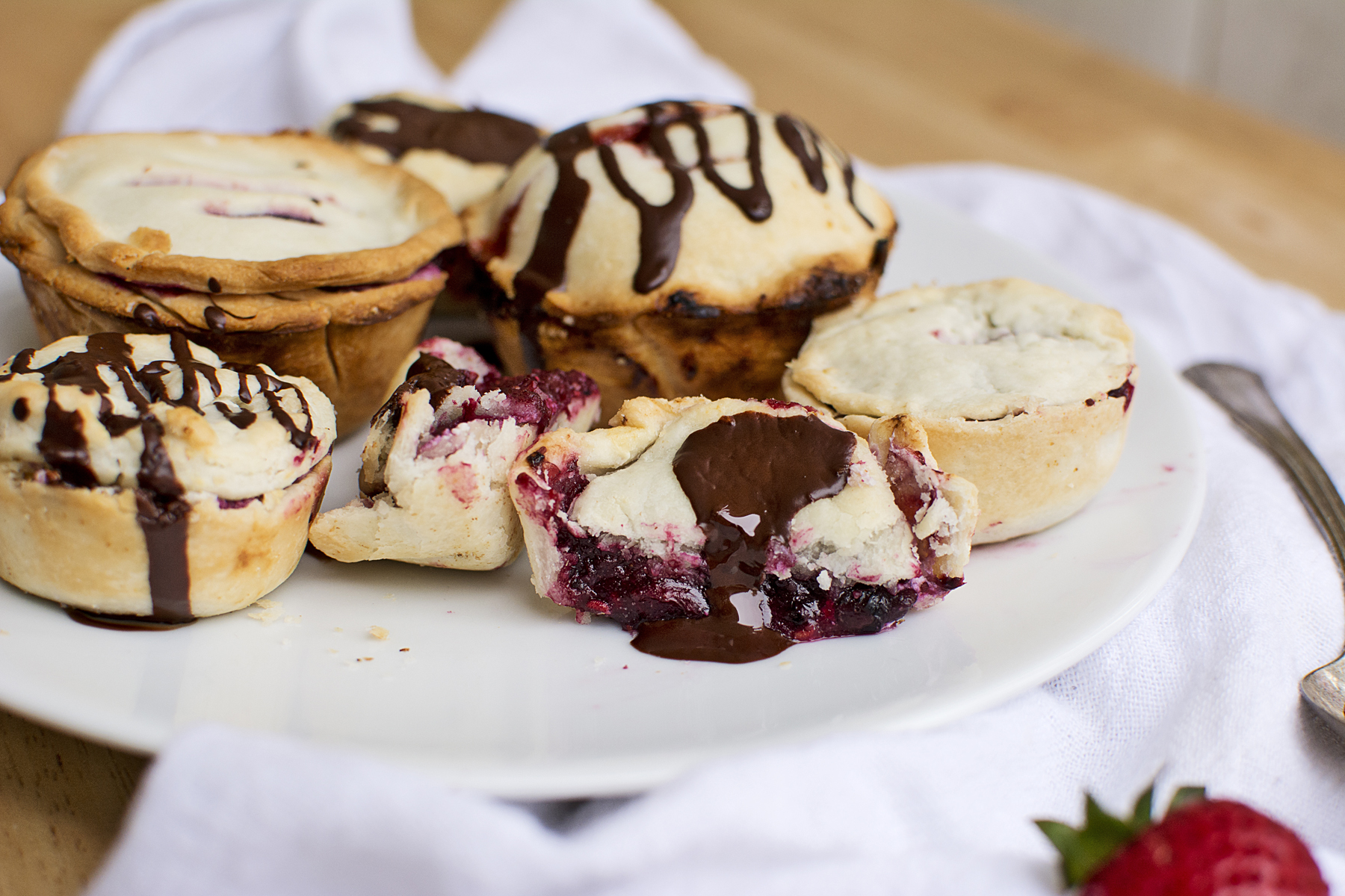 Blueberry, strawberry, and raspberry pies with dark chocolate.