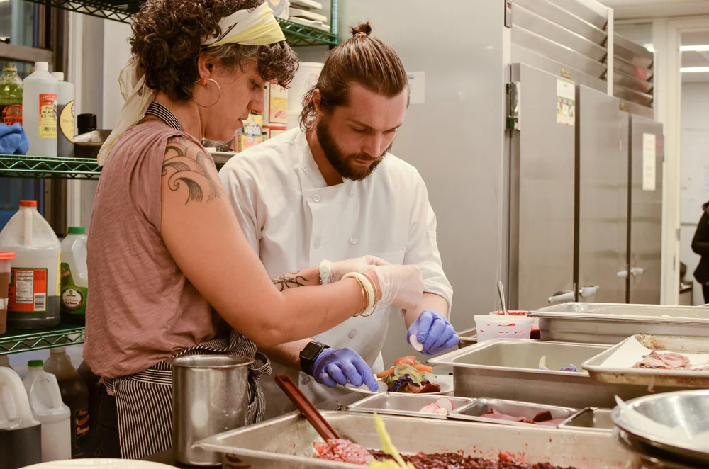 Ora Wise with Chef Dima King working on the plating for Dima’s dish at an April rehearsal of PrideTable at Food Arts Center