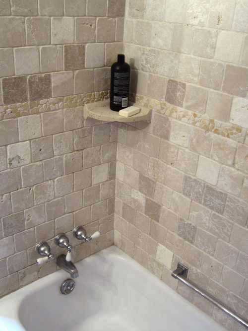 Tumbled marble shower walls, stone mosaic chair rail
