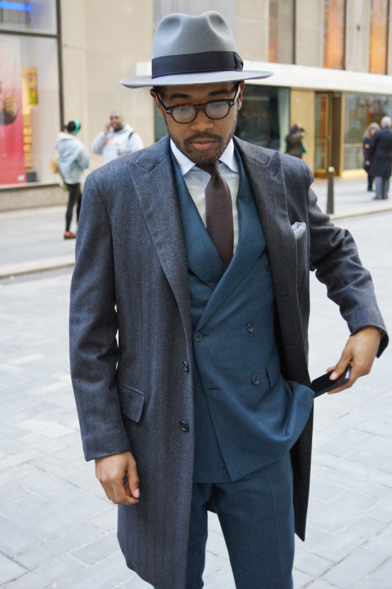 Coat and suit by Brioni, shirt by Piatelli, tie by Isaia, hat by Selentino, eyeglass frames by Tom Ford