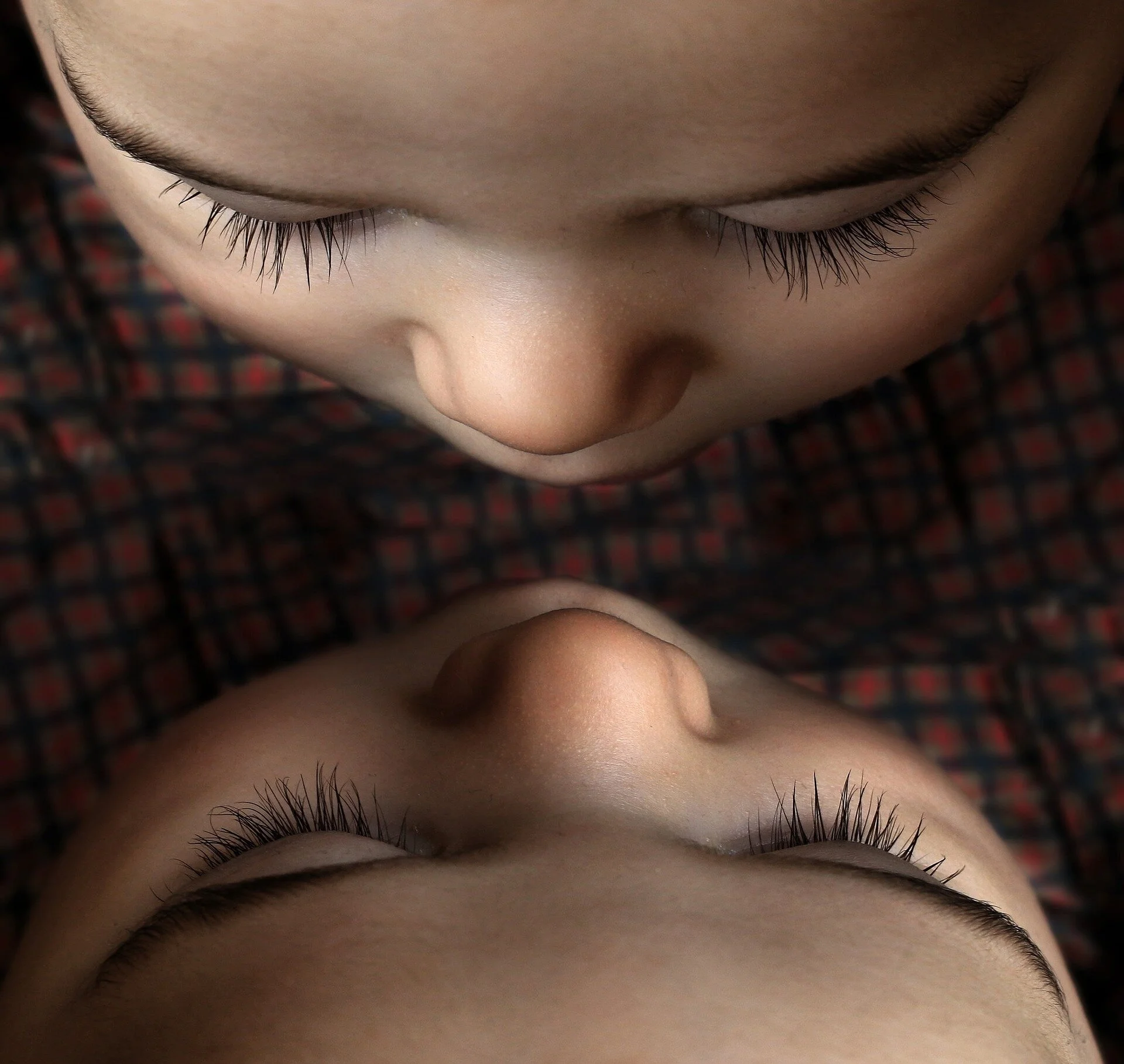 Mirror image of a young child’s face, eyes closed, photographed from above