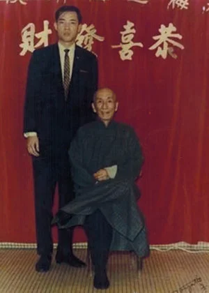 Grandmaster Moy Yat (left) with his Sifu, Grandmaster Yip Man (seated).