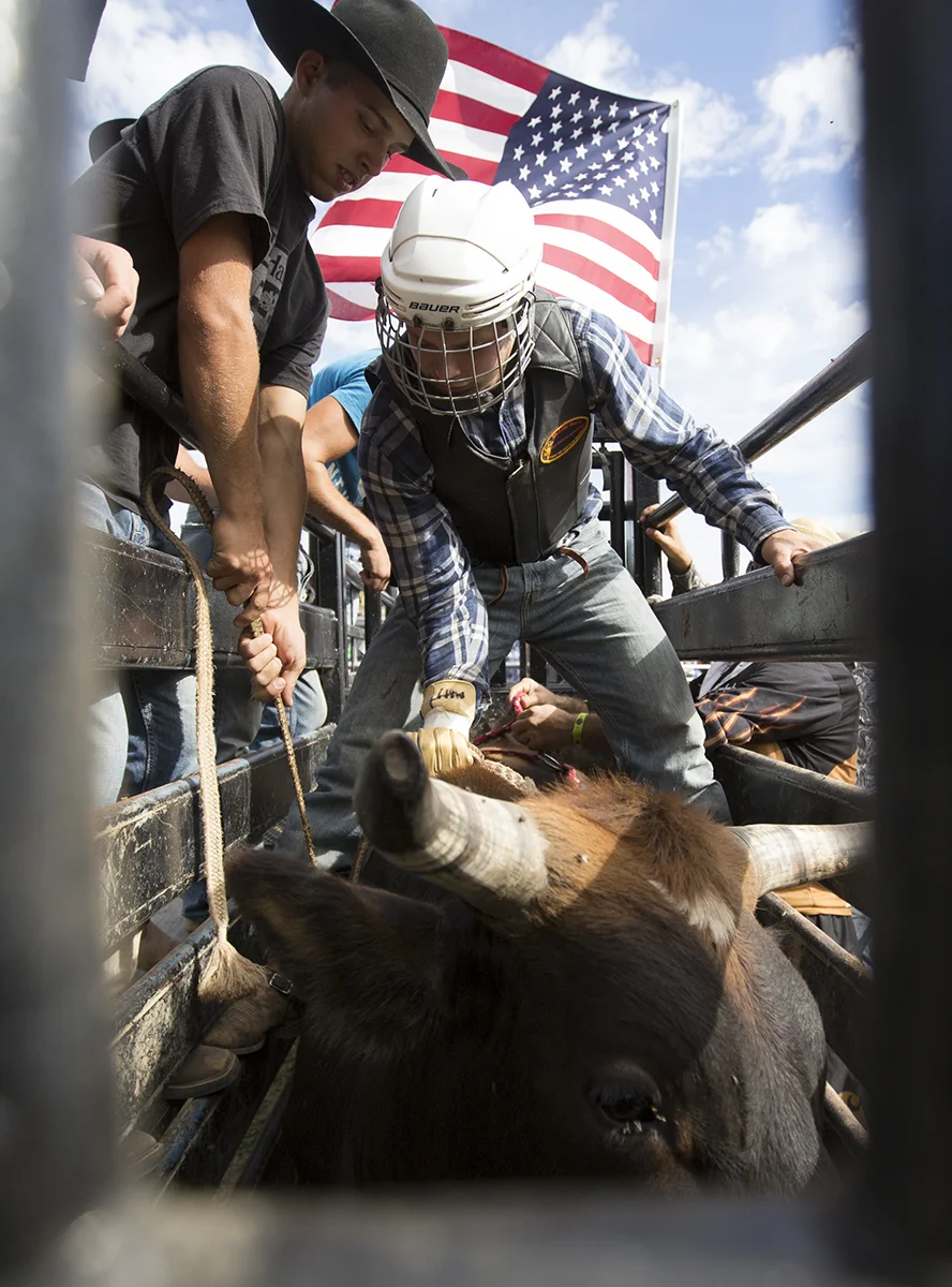 Nathan Troyer (left) of Apple Creek, Ohio, helps Matt Weaver of Sugarcreek, Ohio, prepare to ride Buck Cherry in the novice competition of the Saddles and Spurs Rodeo at Autumn Breeze Farm in Wilmington, Ohio, Sunday, Sept. 15, 2013. The event was the third in a string of six rodeos in the 2013 Autumn Breeze Farm Fall Saddles and Spurs Rodeo Series.