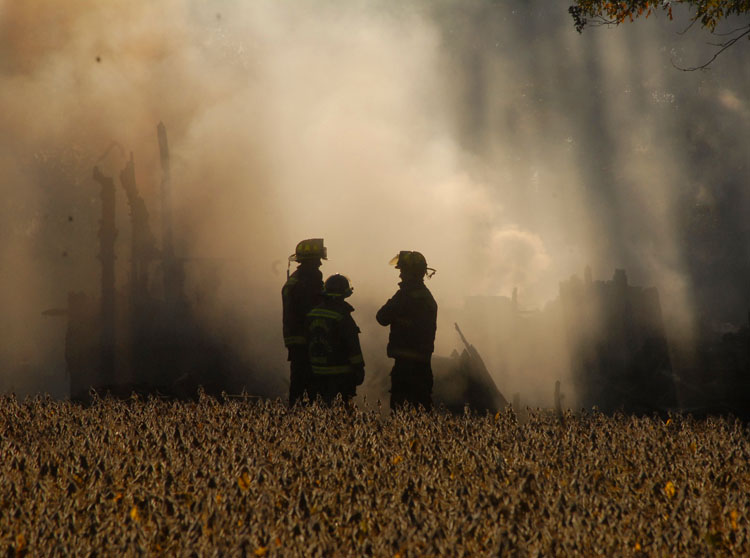  Three Dinwiddie firefighters stand in front of the smoldering ruins of a house that caught fire Thursday afteroon in the 13406 block of Old Stage Road in Dinwiddie, Va. Copyright: The Progress-Index 