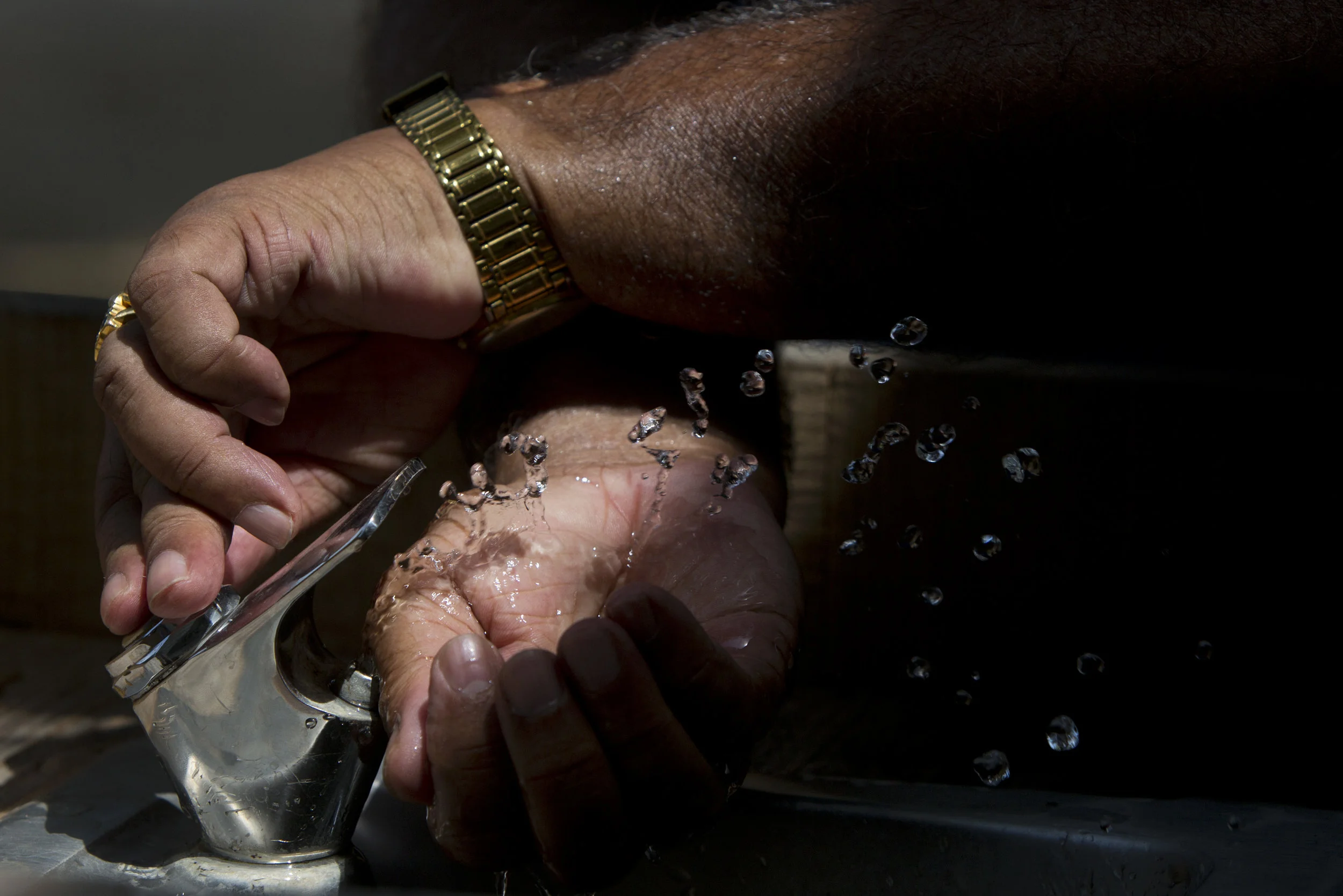 A man fills his hands with water to drink in Colonial Williamsburg while exploring the historic site with his family Monday, July 25, 2016. Copyright: The Daily Press