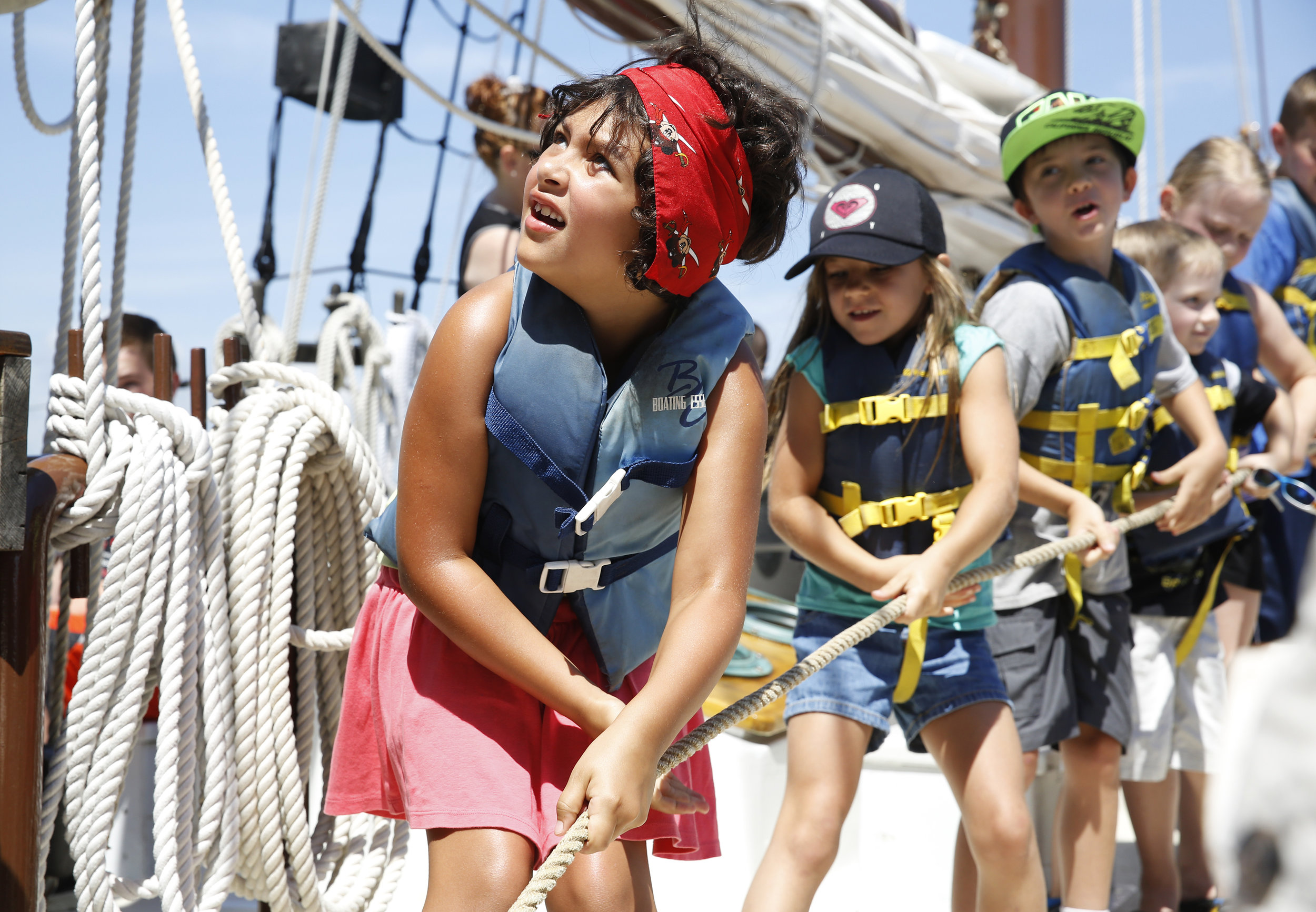  Kara Flexer (from left), 7, from Delaware, looks up at the mast as she works to raise it on the Alliance alongside Rowan Reed, 7, and Jake Reed, 8, from California, Wednesday, June 29, 2016. They were sailing with the Yorktown Sailing Charters' pira