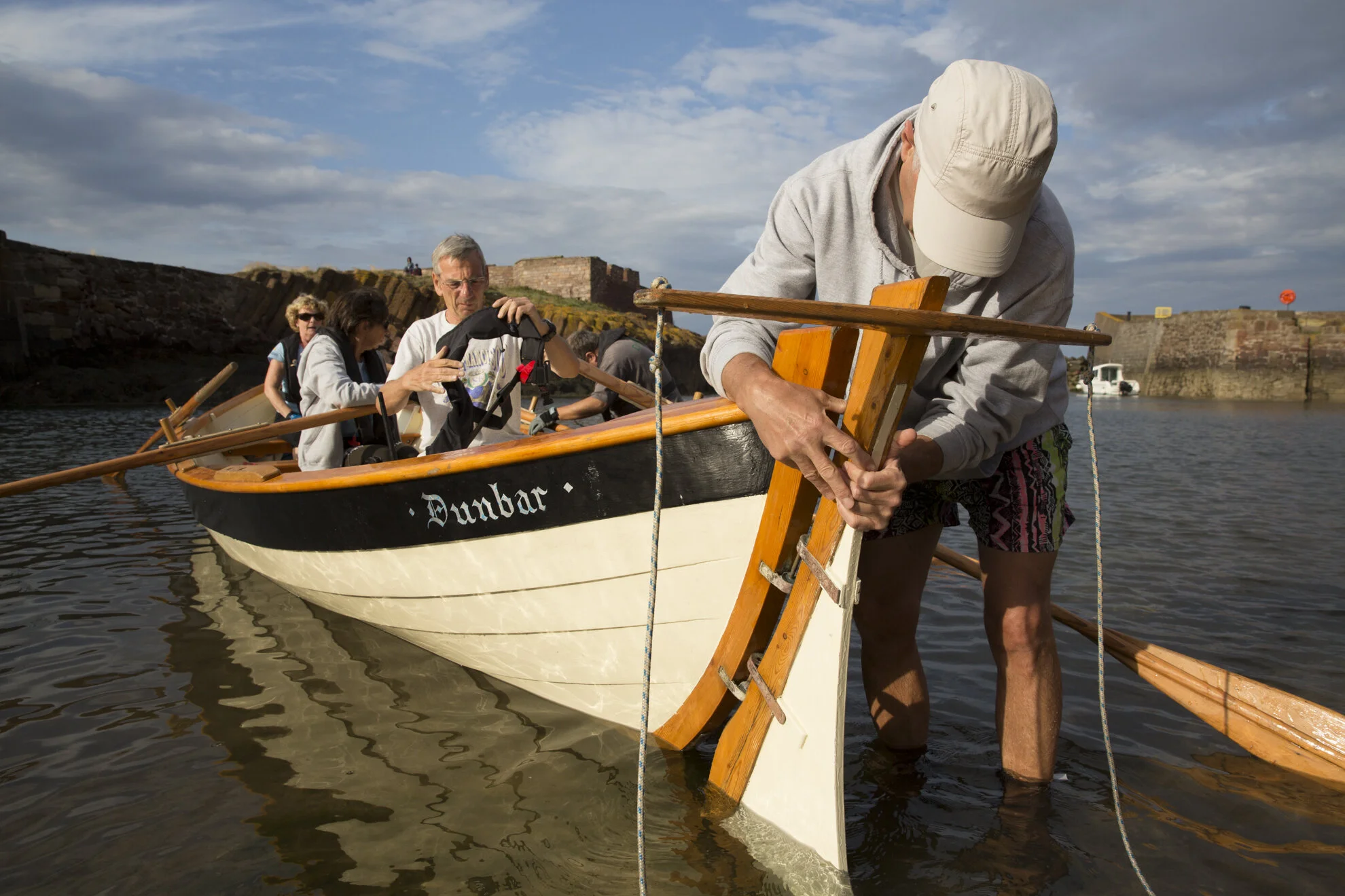 Kenny Maule secures the rudder to the Dunbar Coastal Rowing Club's boat, "Black Agnes", before coxing the boat.
