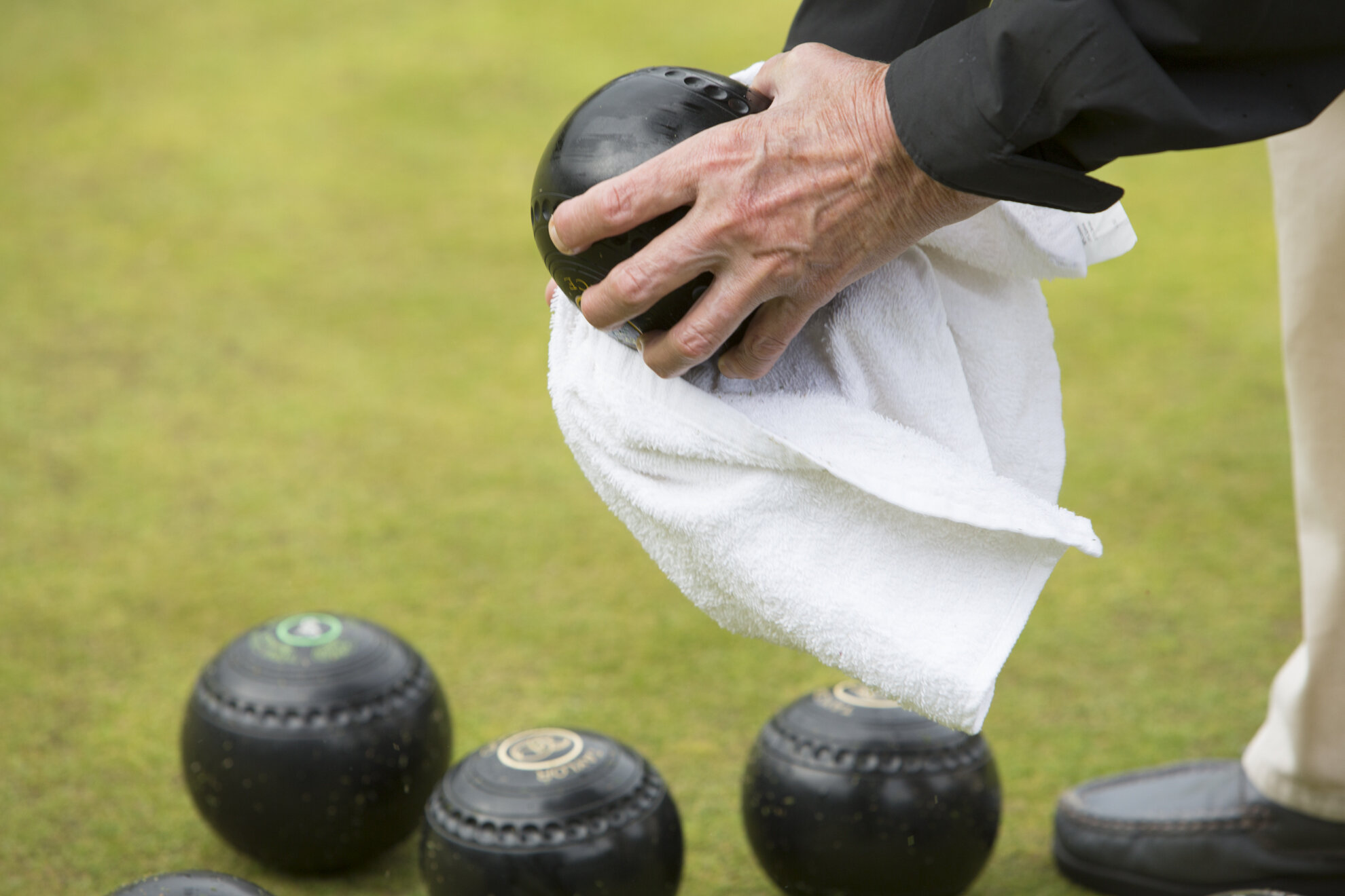 Janet Wright wipes raindrops off her bowls during a friendly ladies game of lawn bowling at Blackhall Bowling Club.
