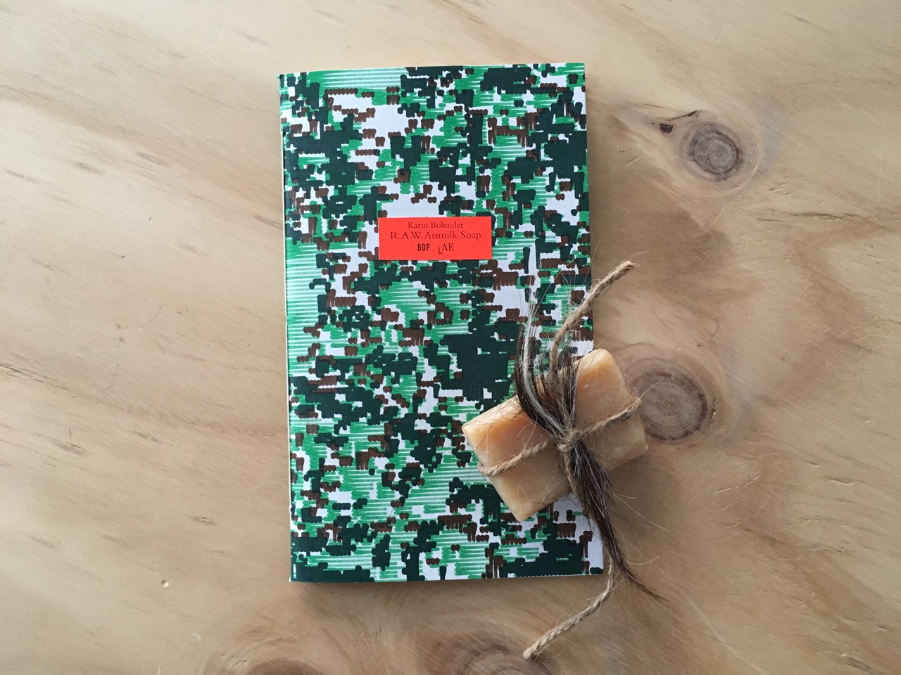 R.A.W Assmilk Soap by Karin Bolender Launch date: November 24, 2016 ISBN: 978-3-943196-53-5 Edition: 75, 12x20cm Special Limited Edition with Soap: 25, 12x20cm Design: André Fuchs, printed by We Make It and bound by hand Karin Bolender’s R.A.W. Assmilk Soap is an essay that describes a multigeneration barnyard-based performance-art practice, which hopes to sidestep Western logocentrism and enquire into human and non-human languages, bodies and companionship, names and unnameables, gender and species, alternative ways of knowing worlds and particular kinds of worldings. The essay involves Aliass, a white-brown-and-black pregnant American Spotted Ass who accompanies Bolender on a seven-week-long journey across the American South in 2002. Astonishingly, their journey is sparked by one simple word, ‘ass’, which is more than just the name of a donkey’s species: ‘ass’ is the American Spotted Ass, but also the “unladylike,” forbidden, dirty word that appears in Holy Scriptures; ‘ass’ becomes a human-posthuman ambiguity that questions certain obstacles to intimacy that naming implies, to finally become a means of connection, an opening to becomings with (Ali)ass’s ways of knowing the world that are other than those of humans. R.A.W. Assmilk Soap also comes in a special, limited edition of 25 with actual soap made with Assmilk. The soap deploys milk as a substance of inscription: a preservation of wordless interweaving of bodies and antibodies, as the milk becomes-with places that the ass’ gestating body has inhabited, as her immune system reacts to everything she eats, drinks, and breathes in her pregnancy. R.A.W Assmilk Soap is the fourth booklet in the Parapoetics Series , co-published with Laboratory for Aesthetics and Ecology, and with cover designs created by André Fuchs (Fuchs Borst), who works conceptually with patterns, translating geometries found in nature that follow fractal, aleatory and aperiodic structures. Parapoetics asks what other semiotic possibilities can be afforded to us, and speculates in parallel vocabularies of alternative sign systems. Parapoetics challenges the idea of what it might mean to signify, in what manner significations can manifest themselves, and what promises for our relation to Others a poetry in an expanded, more-than-human field might hold. Karin Bolender is an artist and poet whose barnyard- and backroad-based performance practice negotiates between human logos and other embodied ways of knowing and becoming. She has lived and travelled with a family of American Spotted Asses since 2002. Through relational performance, writing, video, and sound, she explores dirty words and wisdoms of earthly bodies, in the company of she-asses Aliass and Passenger and their whole muddy ass herd.