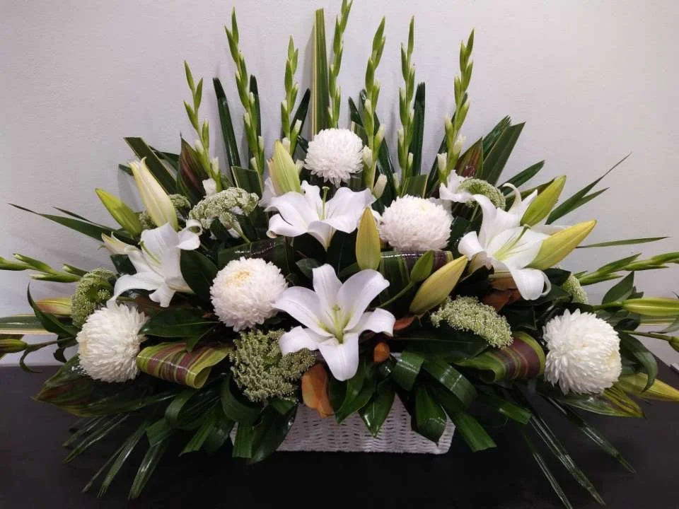 A white lily and chrysanthemum sympathy arrangement