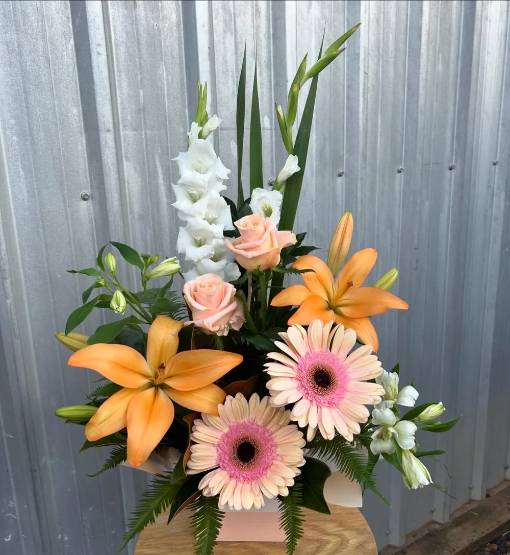 A white and peach arrangement with lilies