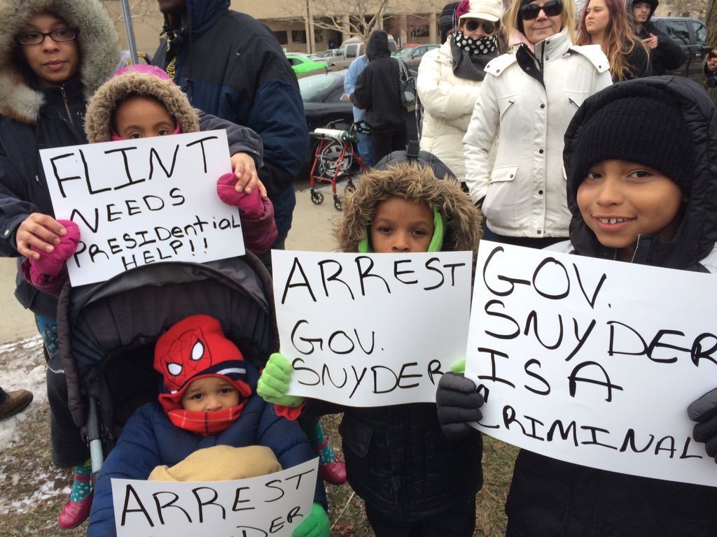 Youth in Flint pick up donated bottled water to replace their poisoned tap water.