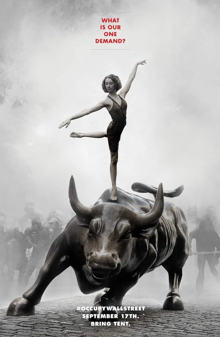 A woman balances on the Charging Bull statue in a foggy setting, with police in the background. Text reads "What is our one demand?" and "#OccupyWallStreet September 17th. Bring tent."