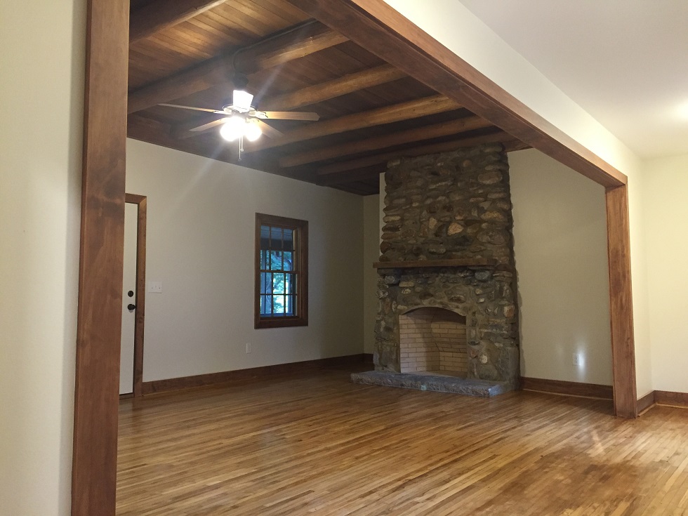  Great room with refurbished stone fireplace and exposed wood beams 
