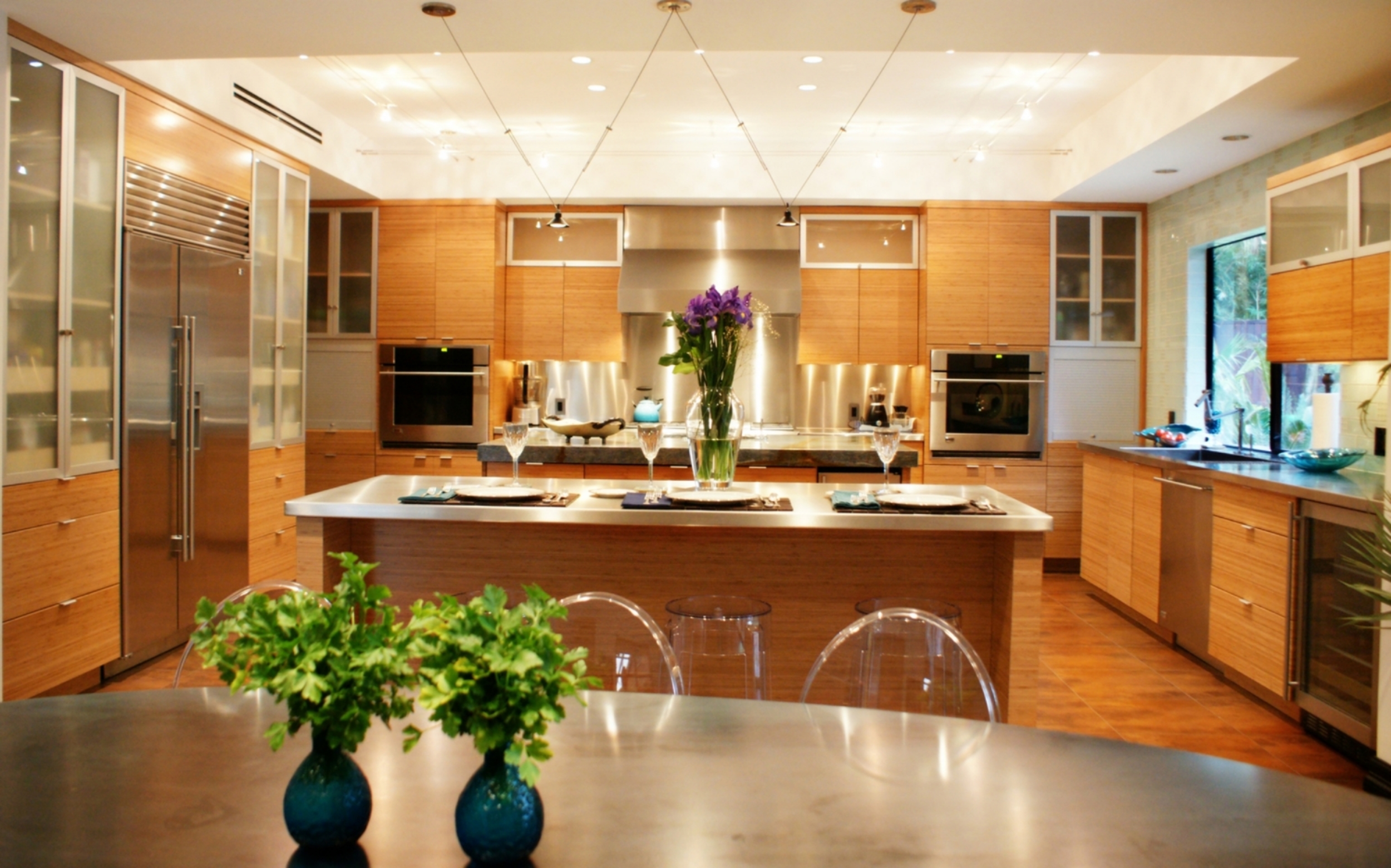Contemporary This stunning contemporary kitchen features bamboo cabinets combined with sleek aluminum framed glass doors and stainless steel countertops. Project location: Houston, TX