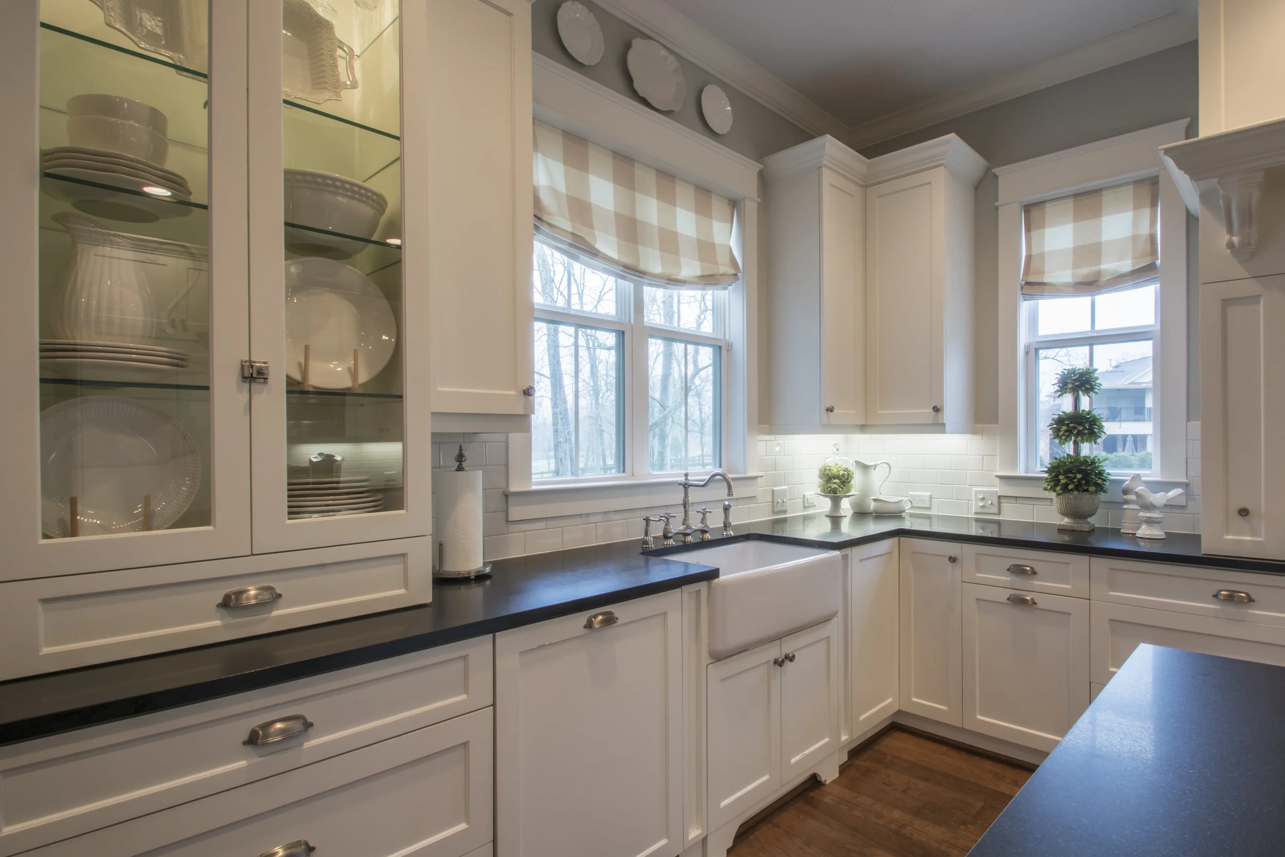 Transitional This beautiful transitional white kitchen has painted shaker cabinets and a custom vent hood with an island designed for extra seating. Project location: Houston, TX