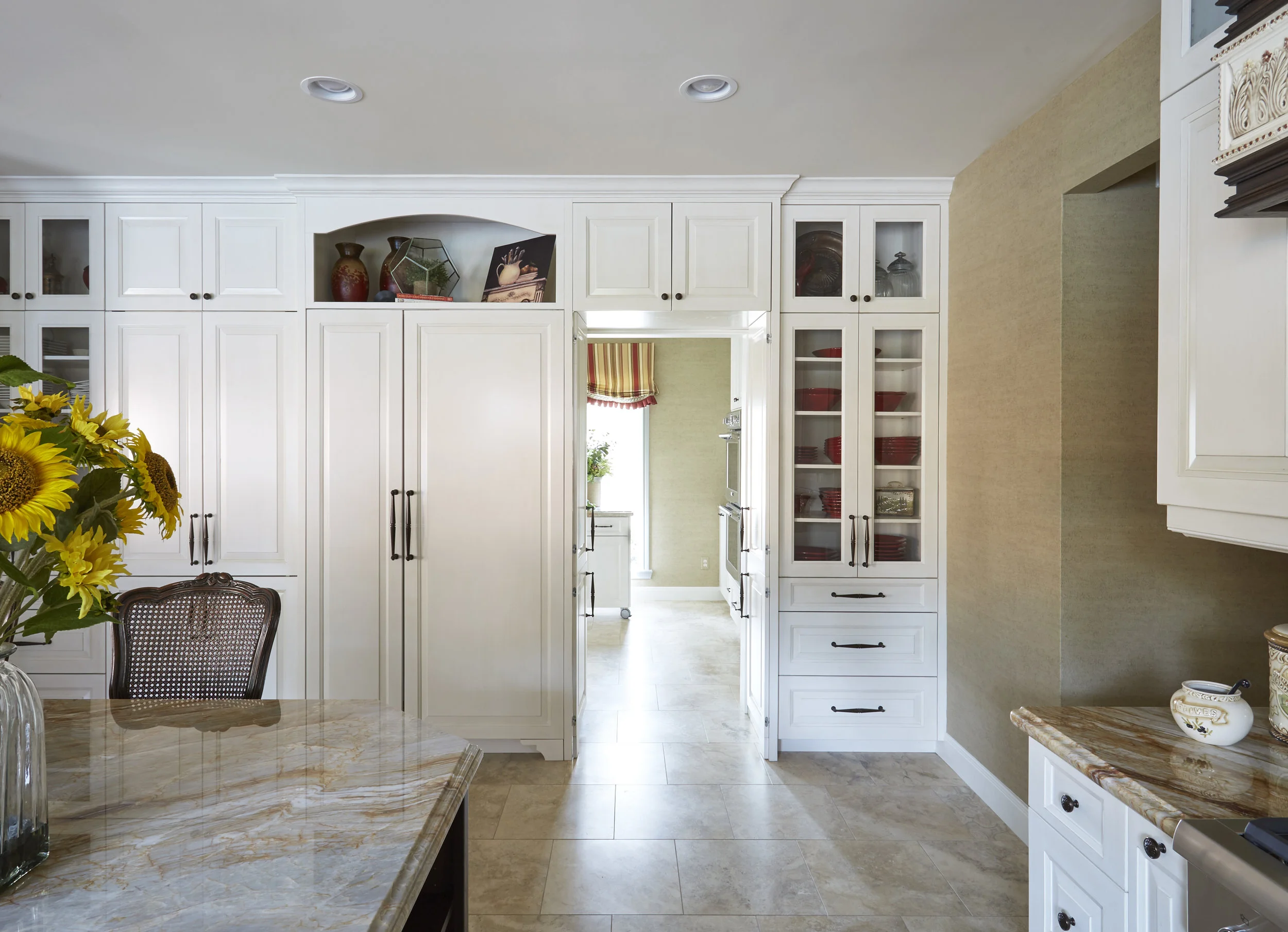 Transitional Kitchen with Hidden Pantry This gorgeous transitional kitchen features exceptional craftsmanship and function - painted cabinets, stained island, and a door leading to a hidden pantry. Project location: Houston, TX