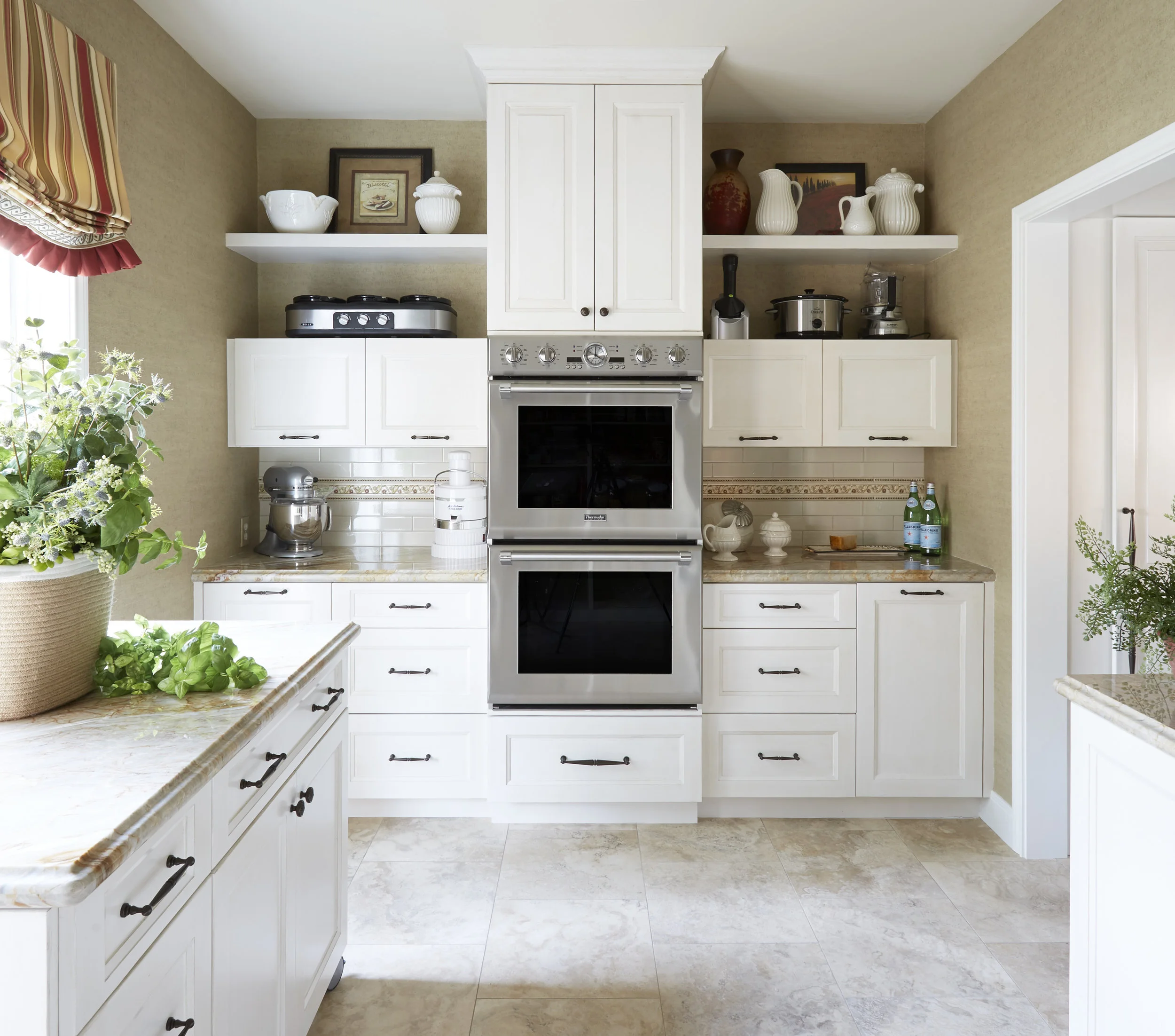 Transitional Kitchen with Hidden Pantry This gorgeous transitional kitchen features exceptional craftsmanship and function - painted cabinets, stained island, and a door leading to a hidden pantry. Project location: Houston, TX