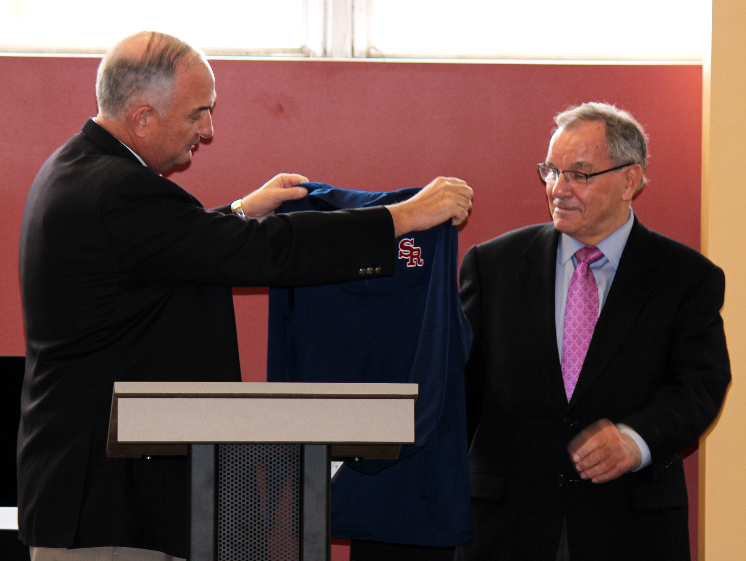 Ernie Mrozek '71 presents Mayor Daley with St. Rita Mustangs shirt.