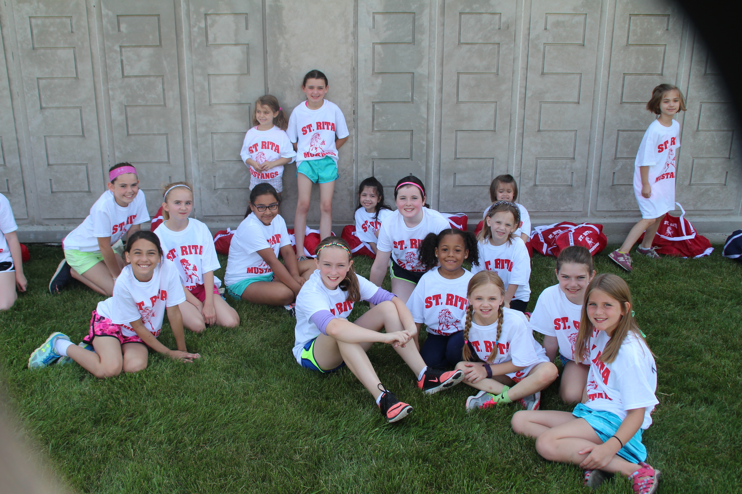 Grammar school girls take a break in the shade from softball