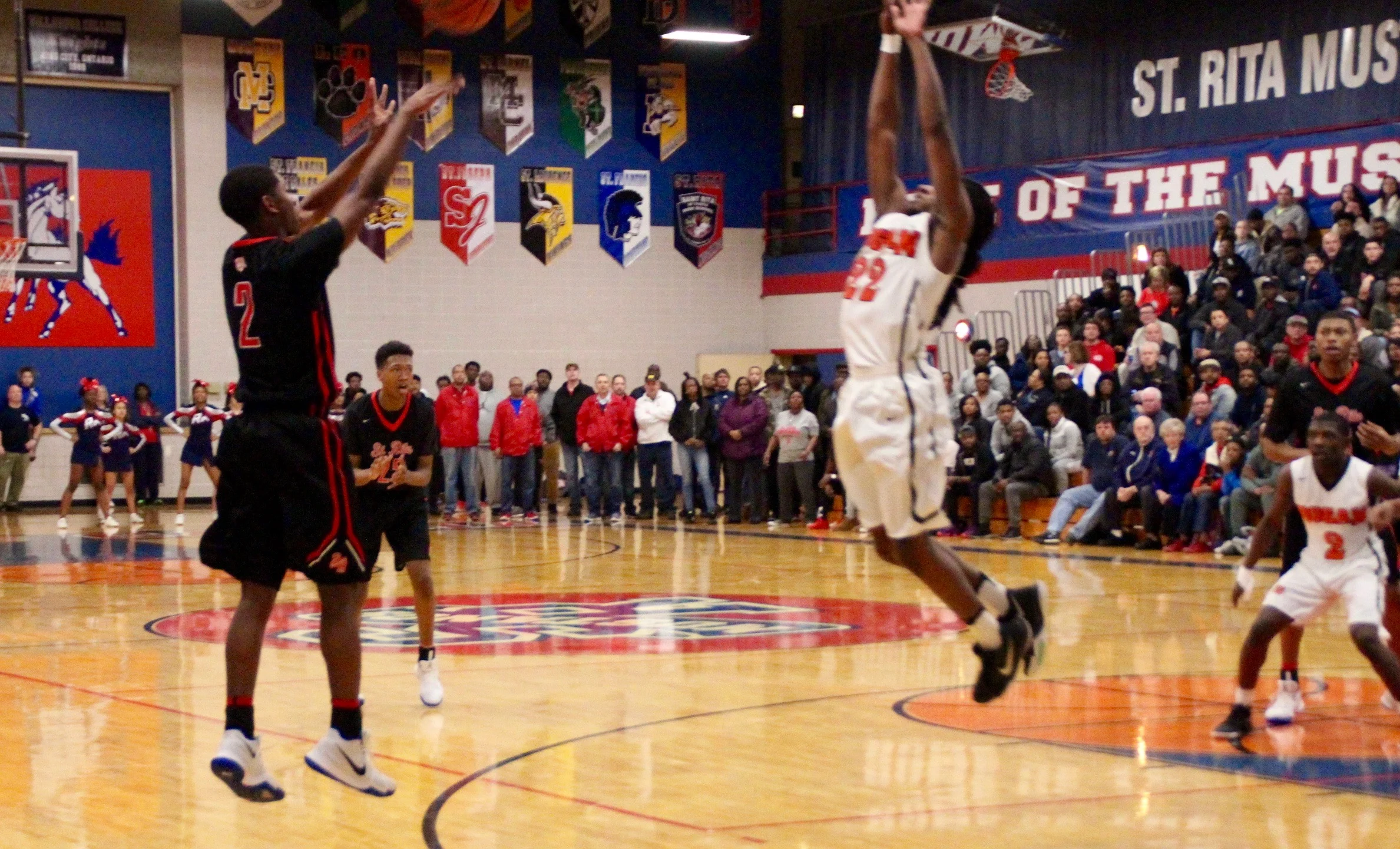 St. Rita's Rashaad Williams fires a three-point shot over a Bogan defender.