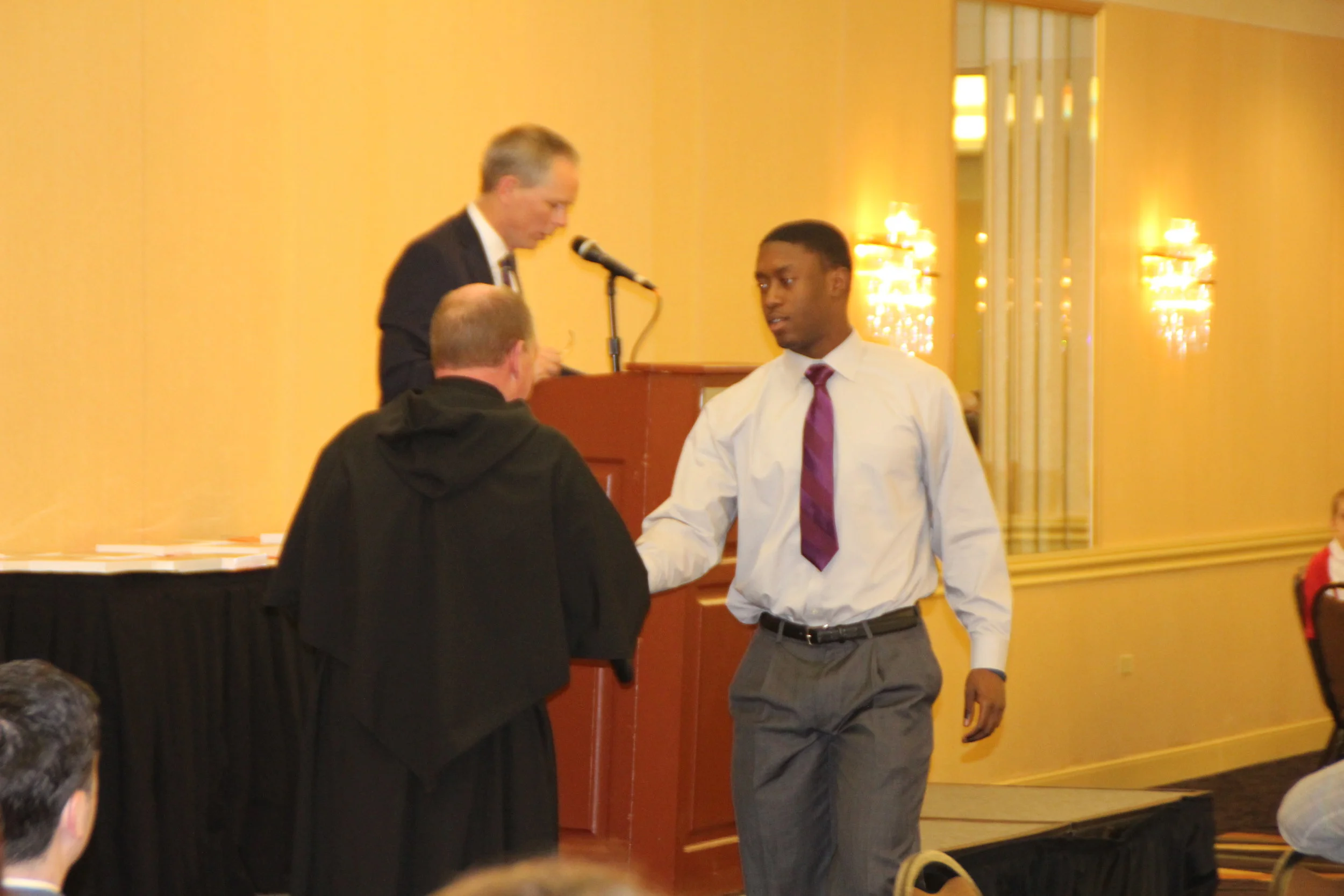 University of Illinois-bound Marc Mondesir is congratulated by Fr. Paul Galetto, Ph.D., O.S.A. at the 27th Annual St. Rita Academic Awards Banquet.