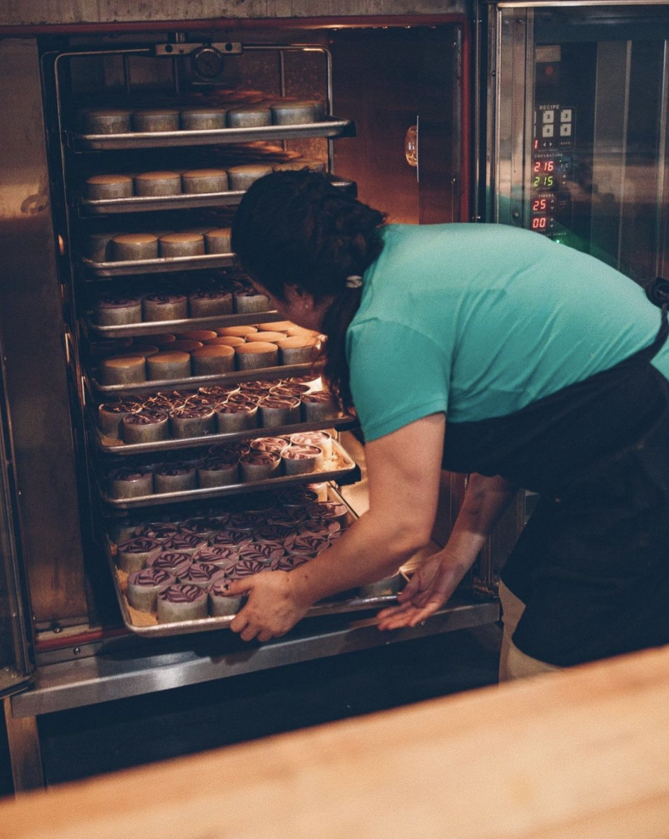 Reyna pulling cheesecakes from the oven