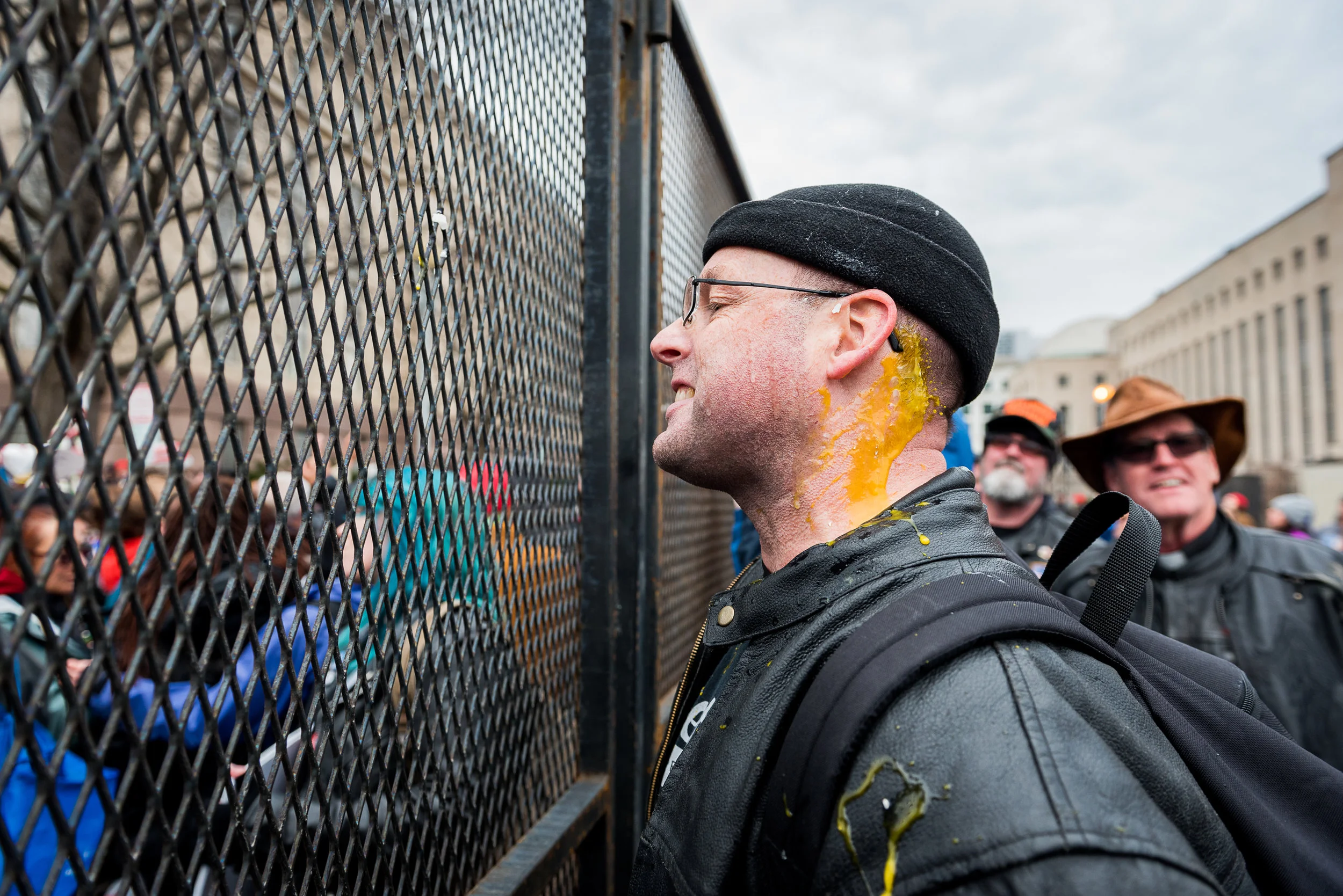 Washignton D.C. resident Chris Z., a member of Bikers For Trump, talks back at protesters through a security checkpoint barricade after being hit in the neck with an egg thrown by a protester, Friday, January 20, 2017.