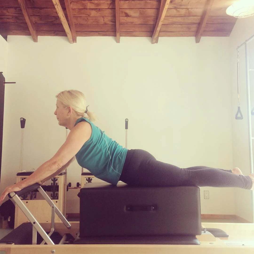 what a lovely swan! by lifting the chest through the arms and sliding the shoulders down the back, Flo is getting a big stretch through her thoracic spine. her belly is pulling in and up to help support her lumbar spine. #projektpilates #pilates #los