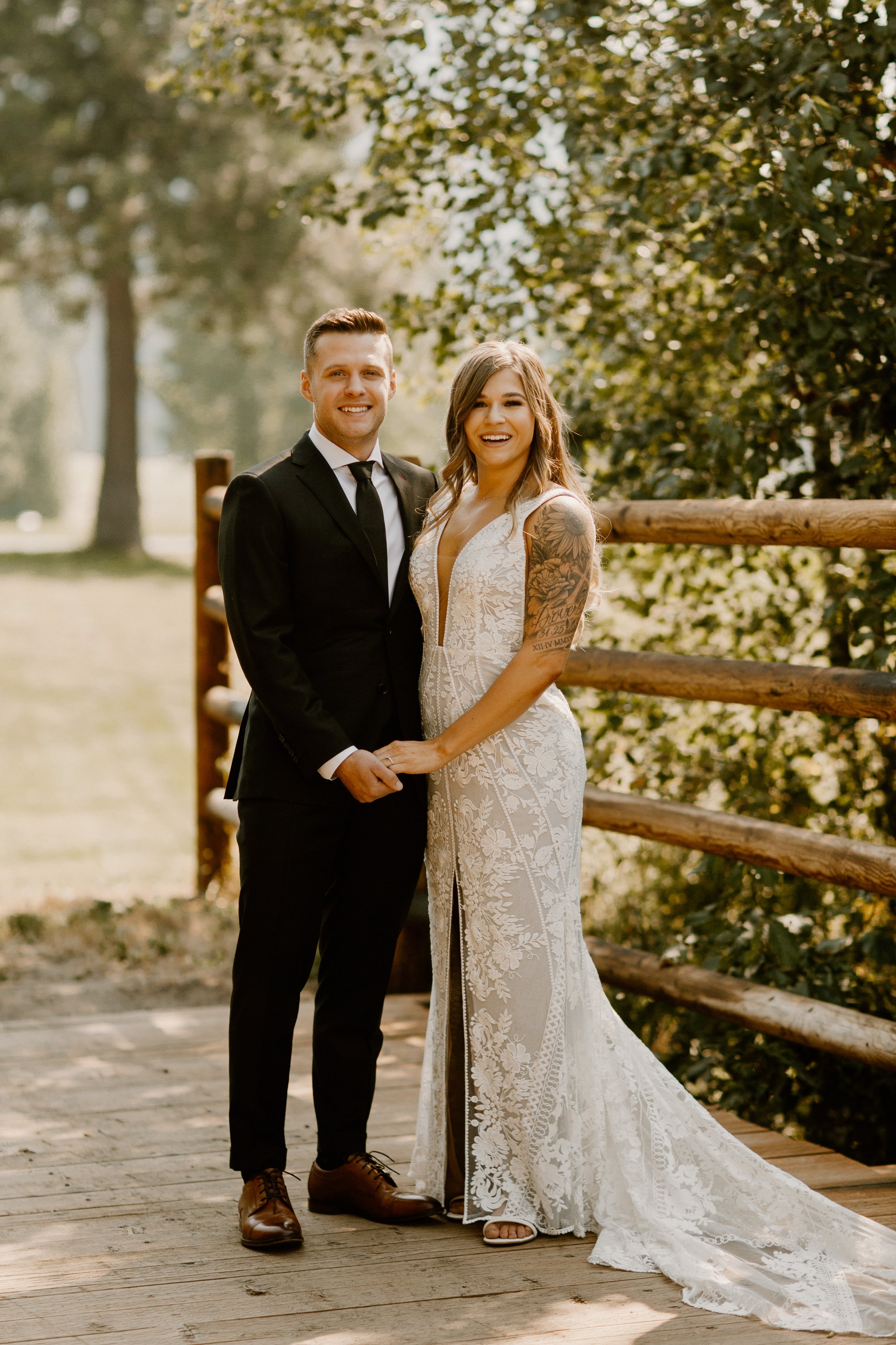 Bride and Groom Smiling at Camera while holding hands