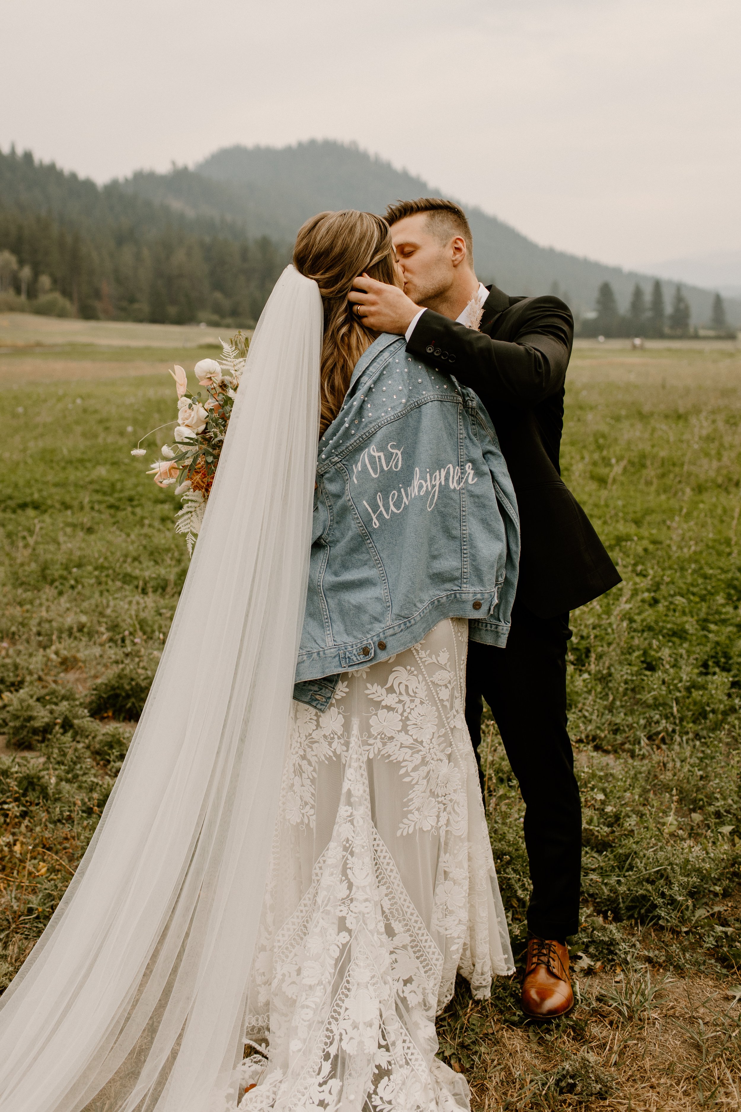 photo of bride and groom kissing with veil in foreground