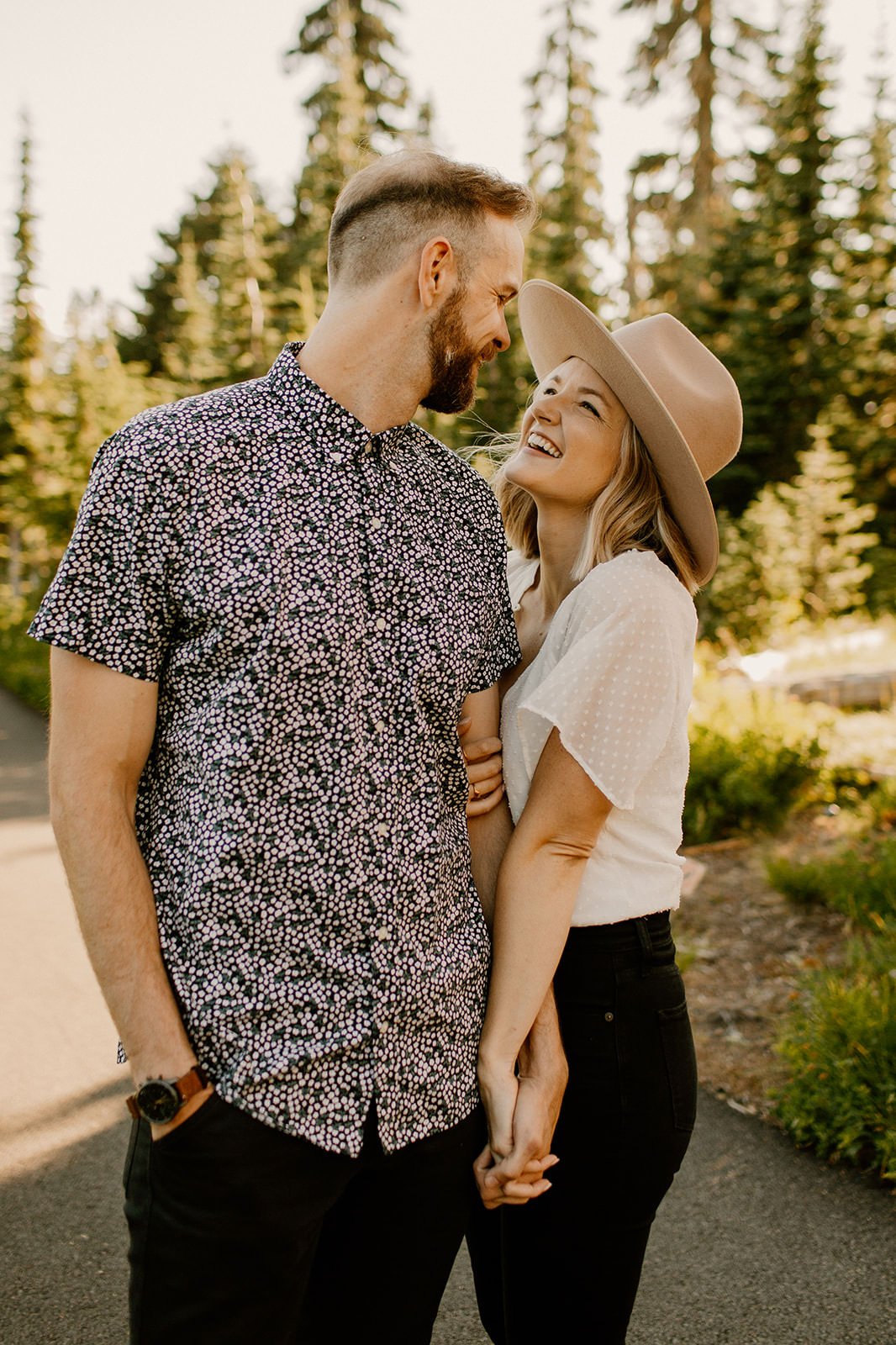 couple holding hands with fiancee looking up at her partner smiling