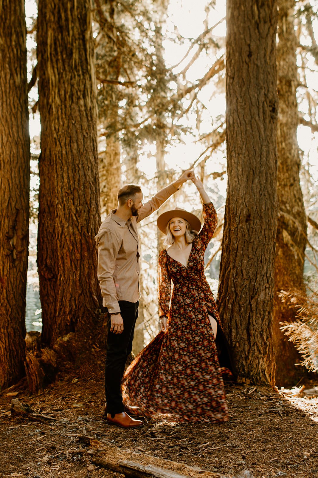 fiance twirling his partner around in the forest at mt. rainier national park