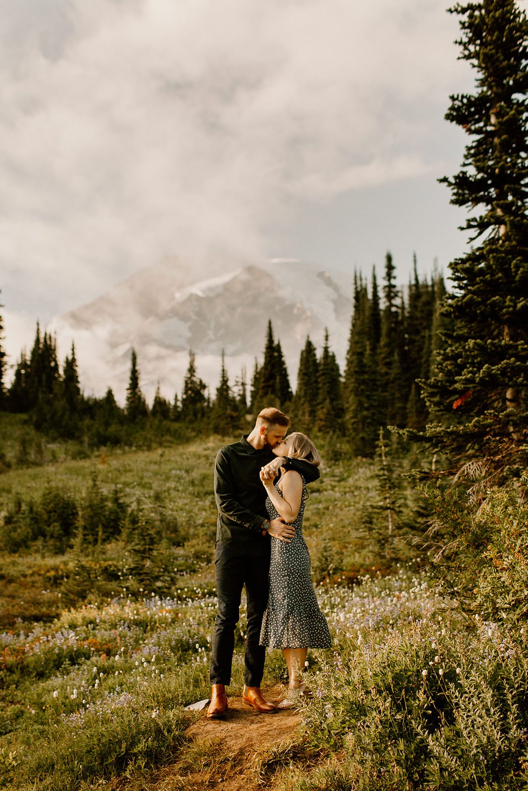 fiance kissing his partner with mt. rainier in the distance