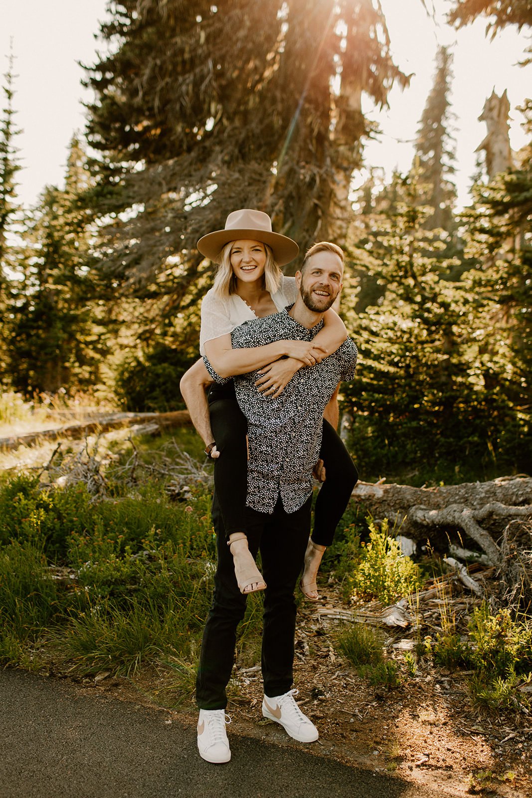 Fiance giving his partner a piggy-back ride in the forest of mt. rainier